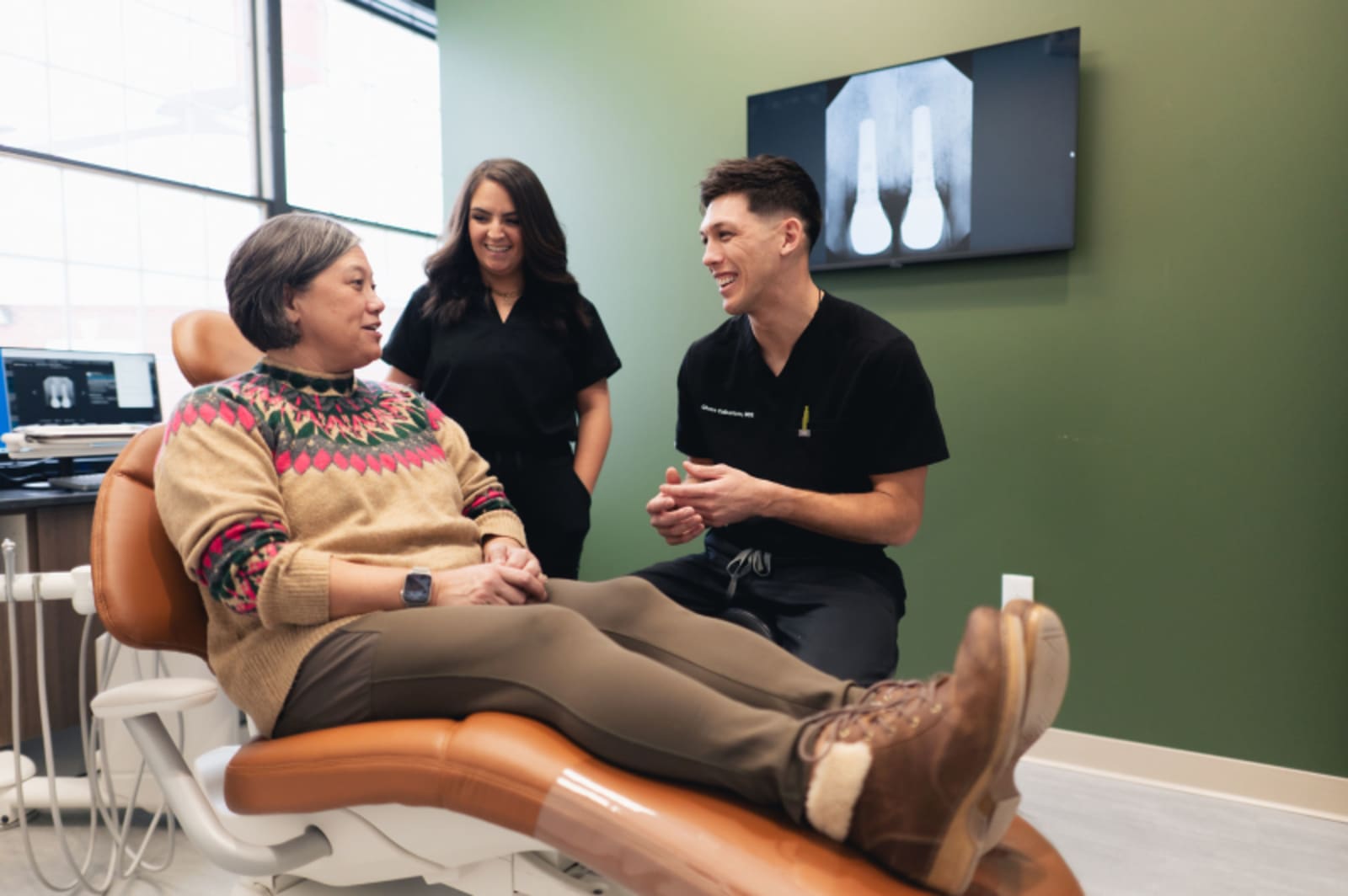 Dental professional showing X-ray results to patient in clinical setting