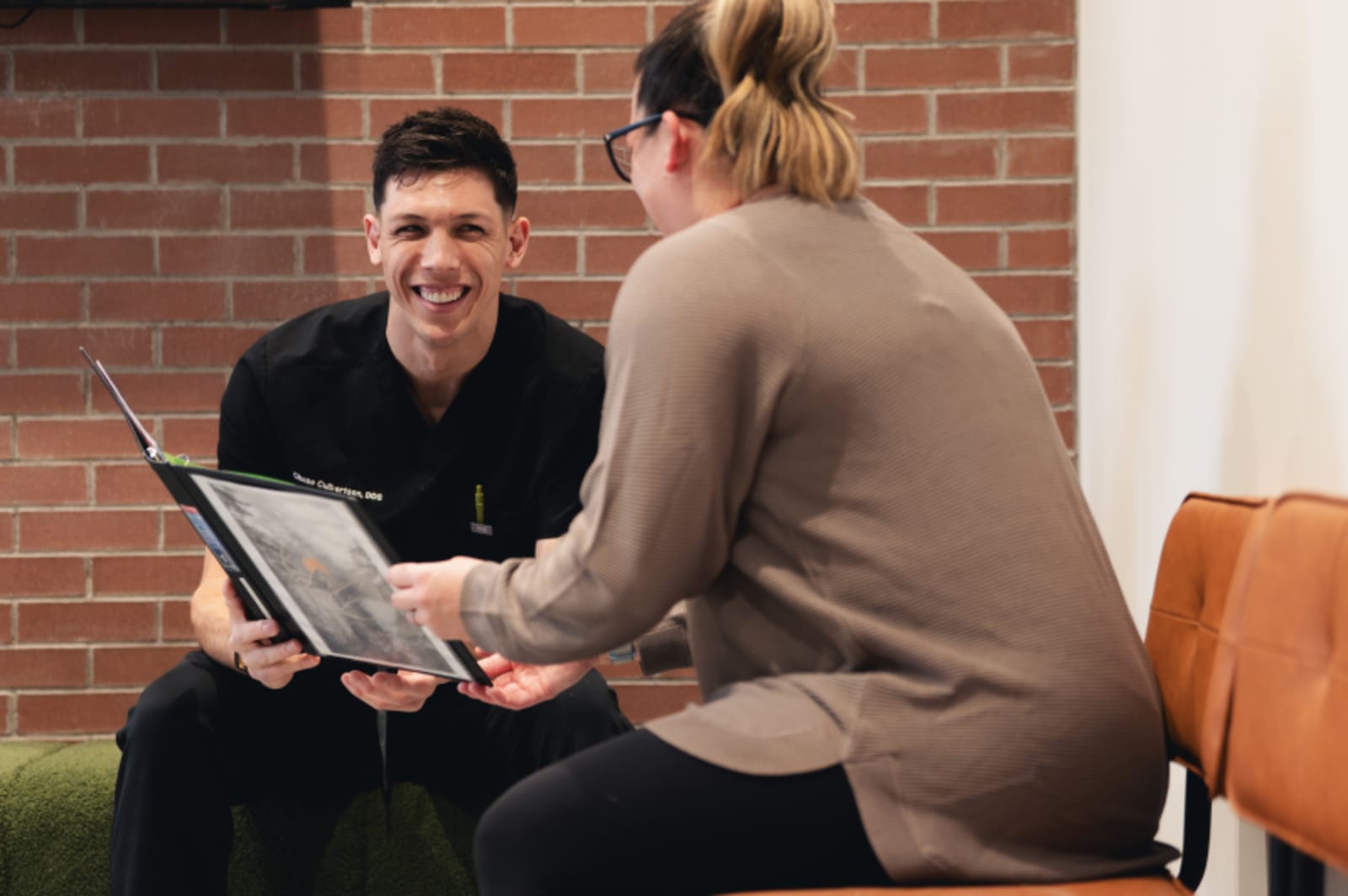 Dentist consulting with patient in treatment chair, explaining procedure