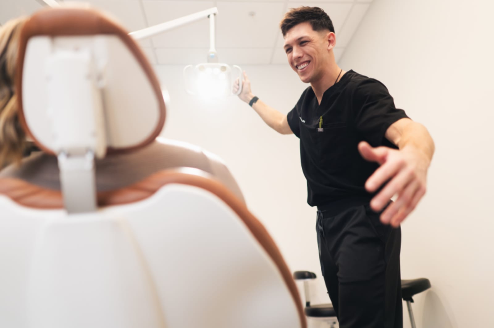 Dentist pointing to dental X-rays during smile design consultation with patient