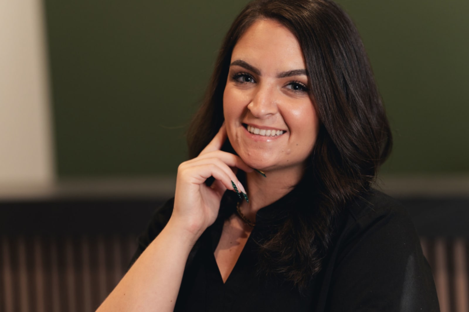Female dental professional in black scrubs smiling, professional portrait