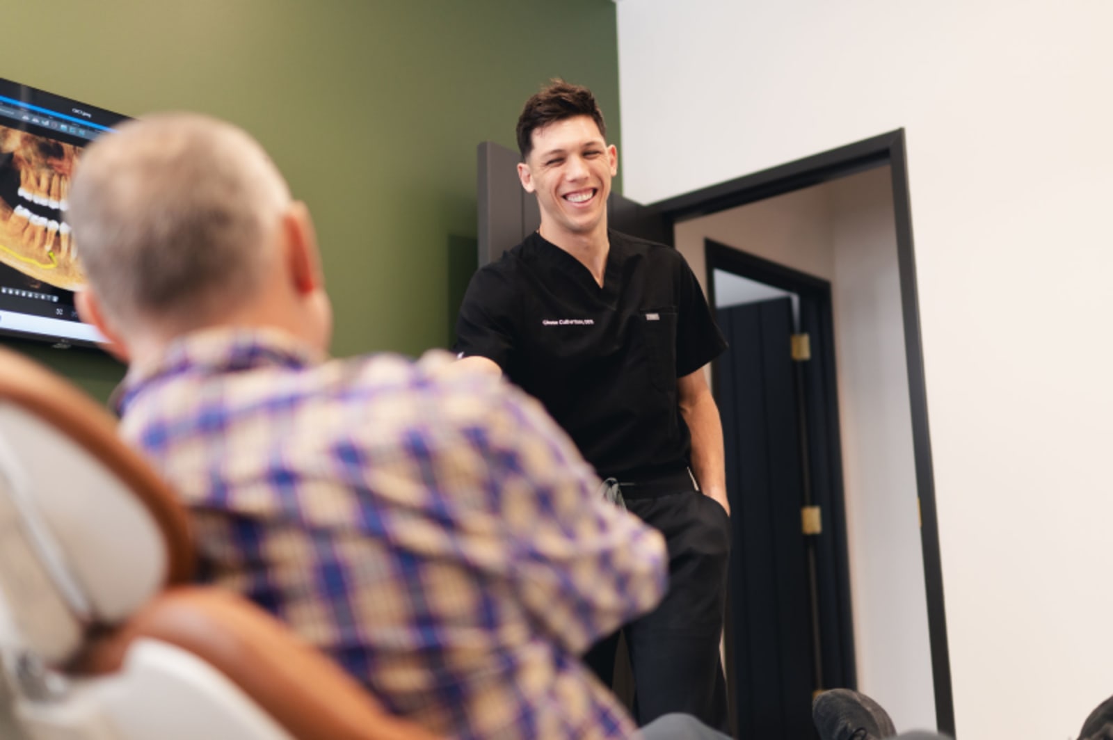 Dr. Chase meeting elderly patient in treatment room at Summit Dental Studio