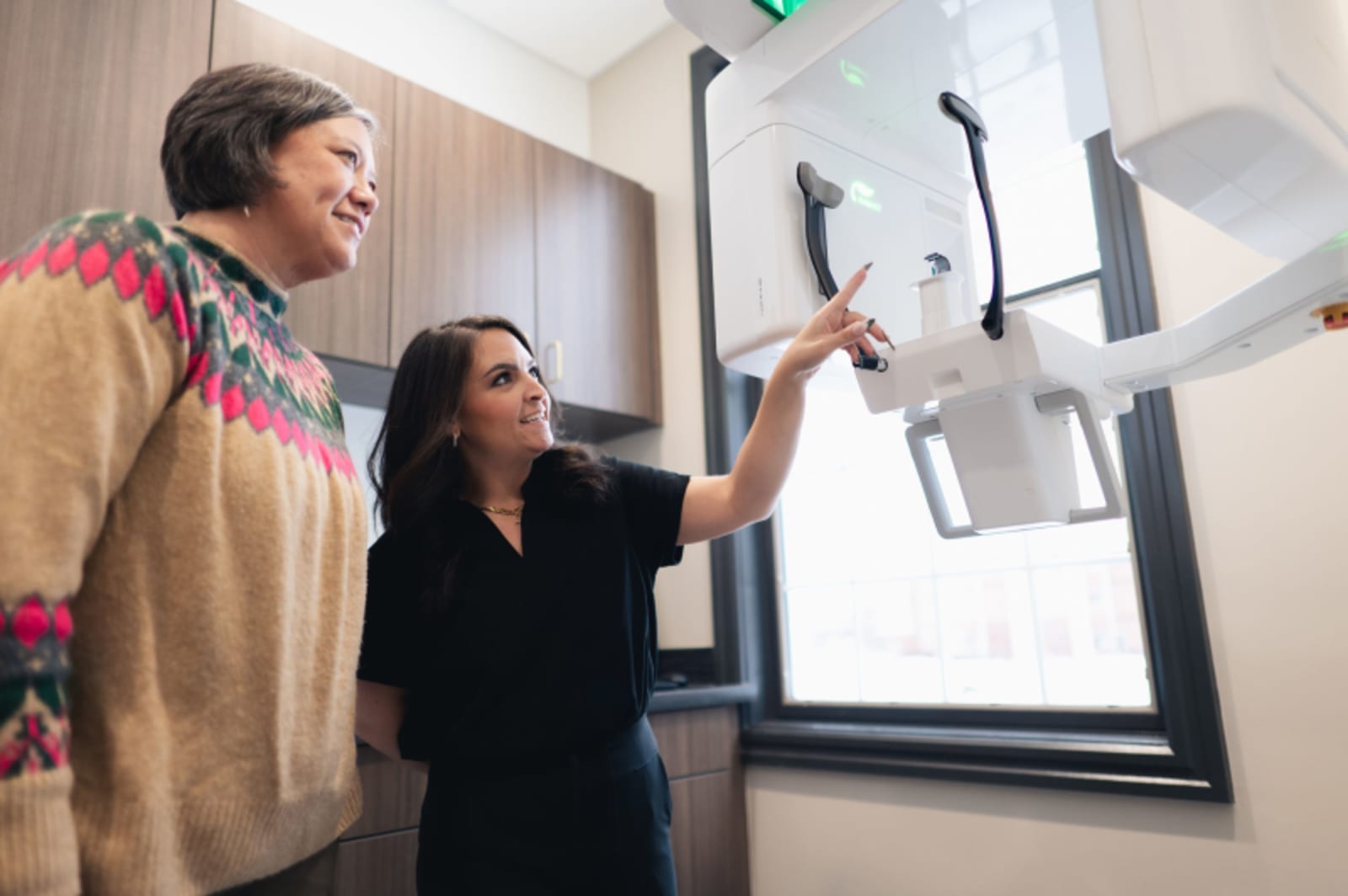 Dentist explaining treatment plan to patient using digital X-ray display