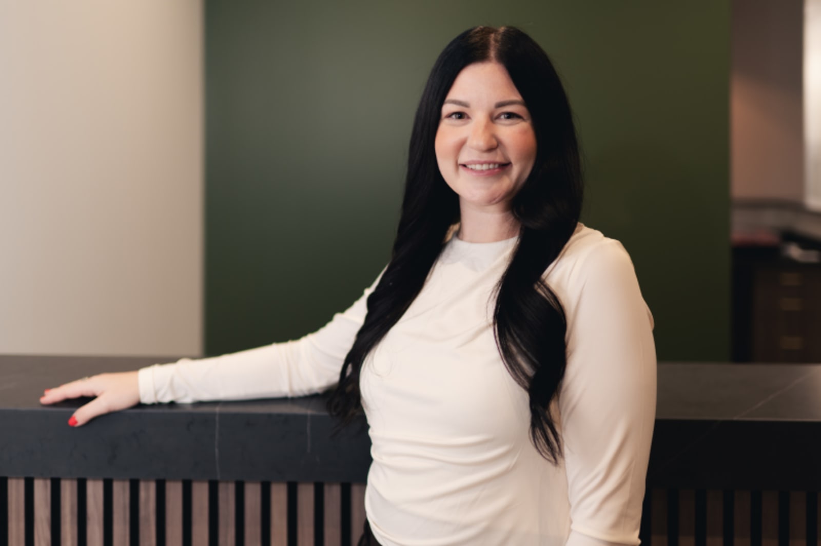 Professional female team member smiling at Summit Dental Studio in clinical setting