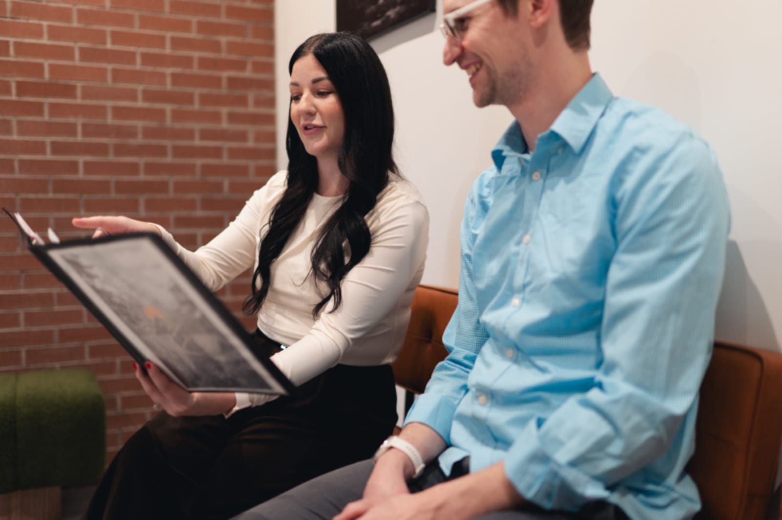 Male dentist in light blue shirt consulting with female patient in waiting area