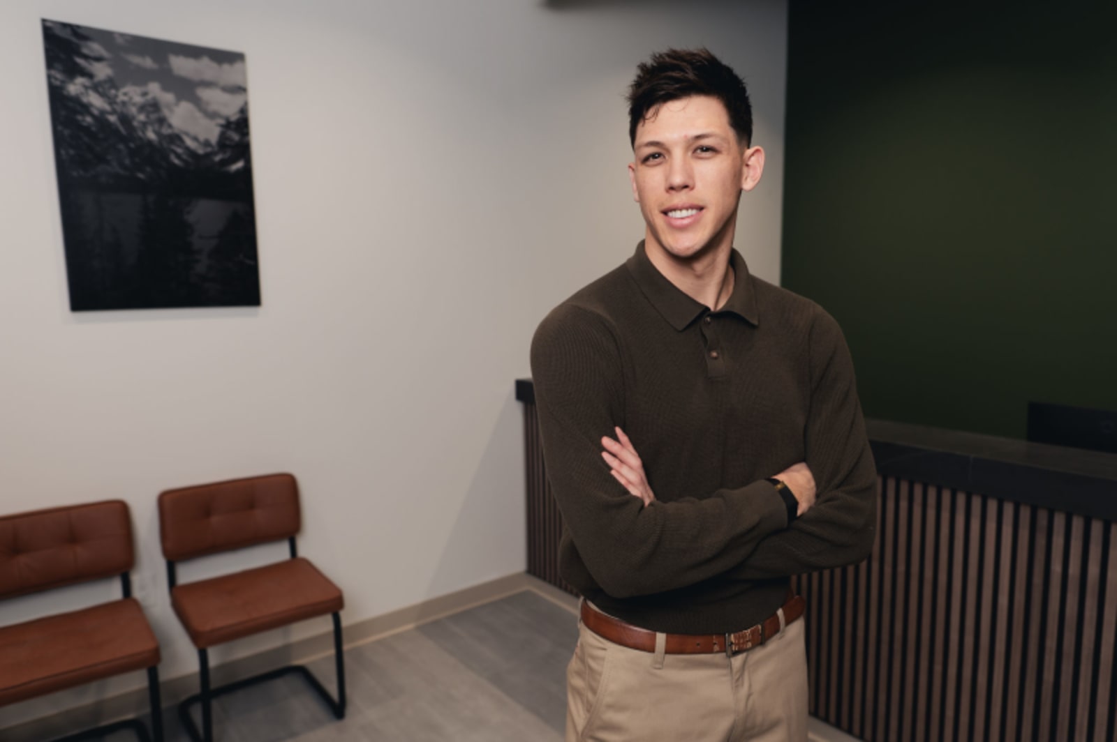 Male dental professional in confident standing pose wearing dark casual shirt