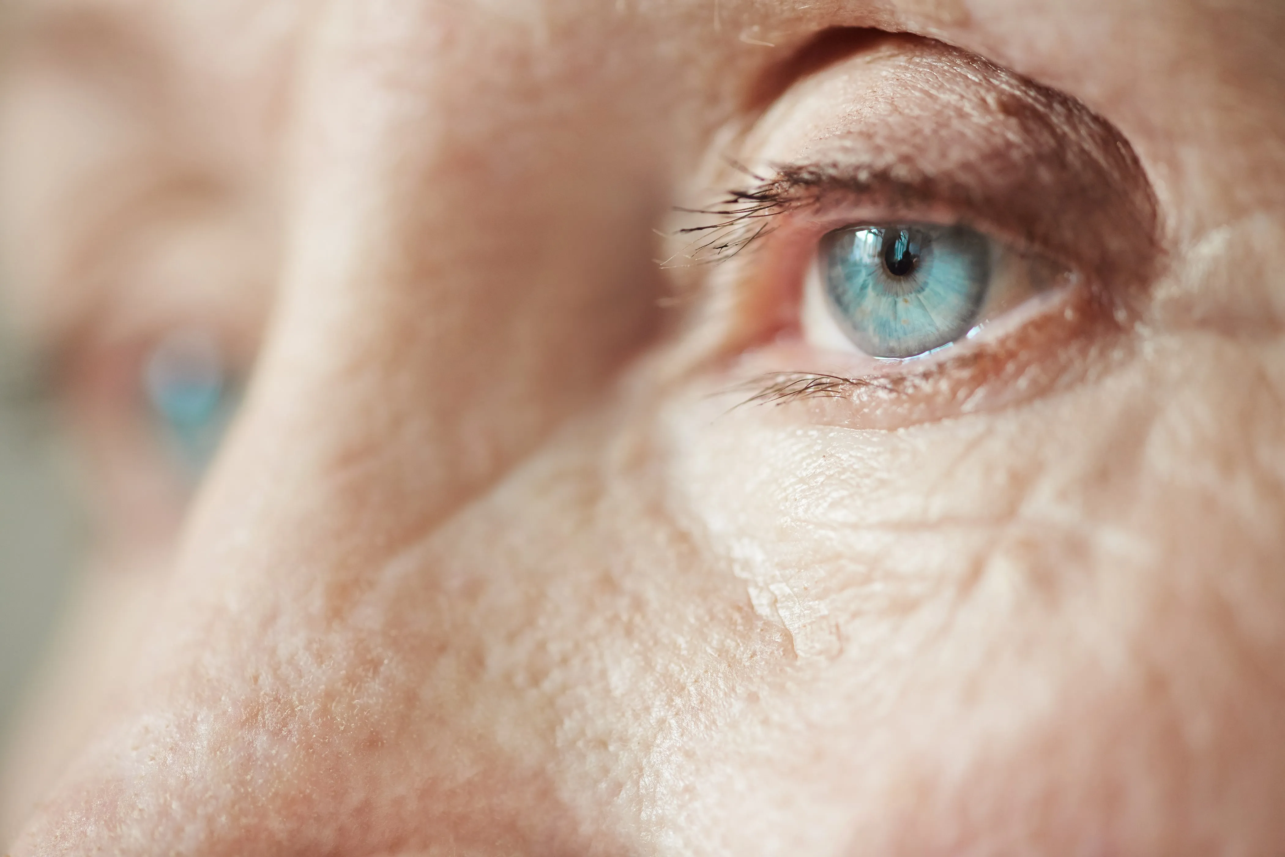 Extreme close-up of a bright blue eye with detailed skin texture