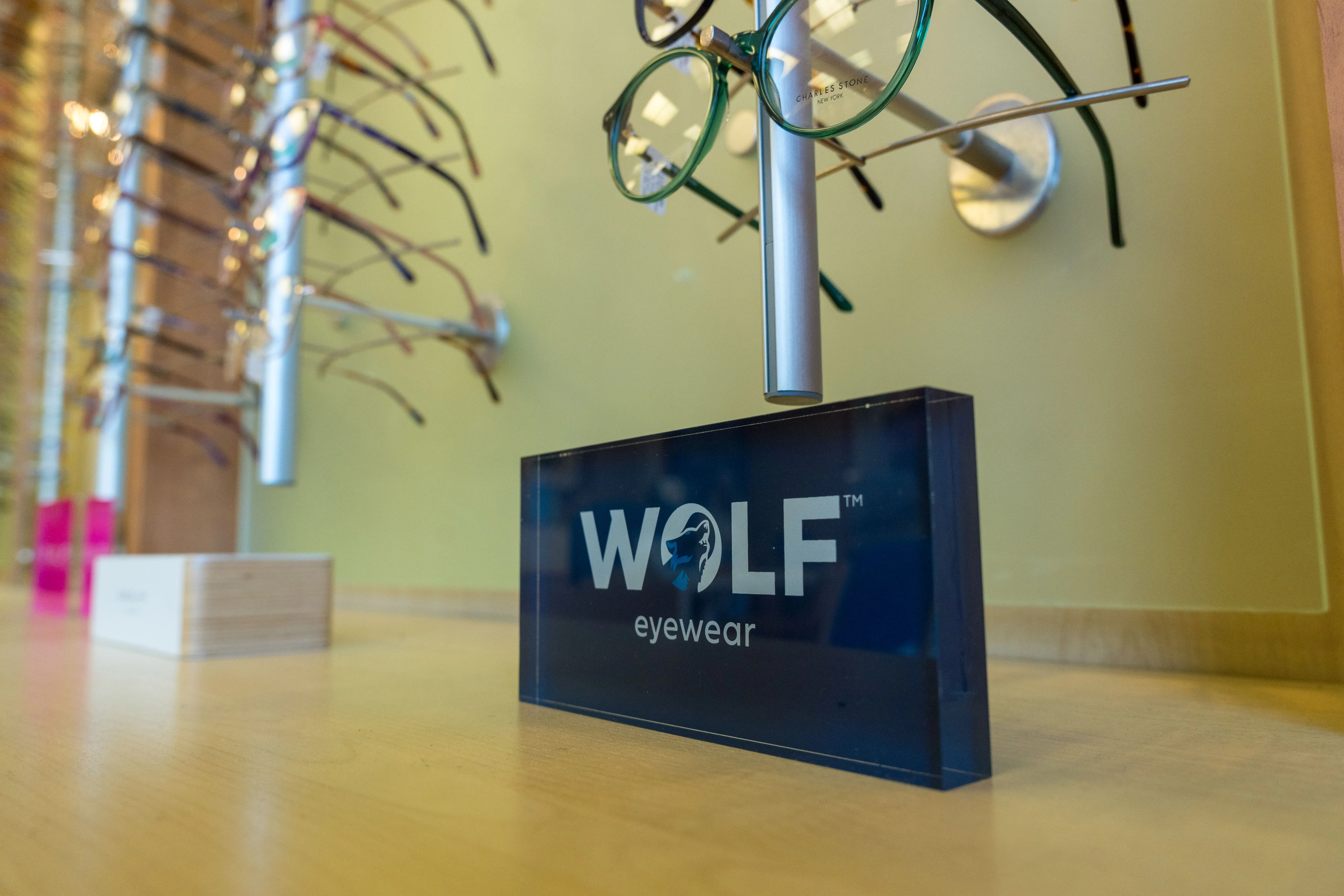 Wolf Eyewear logo with eyeglasses on display stand