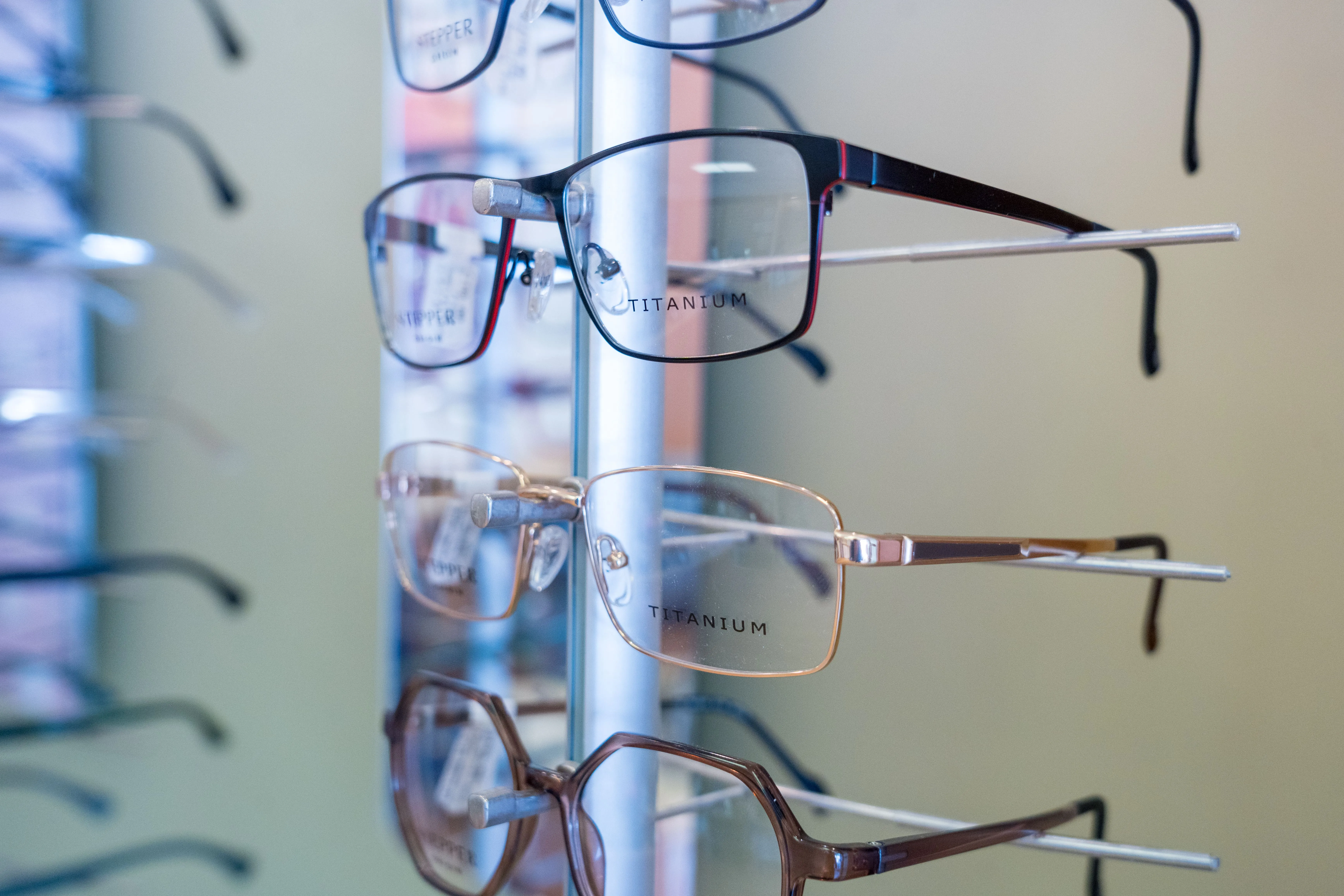 Titanium eyeglasses hanging on display rack in optical store