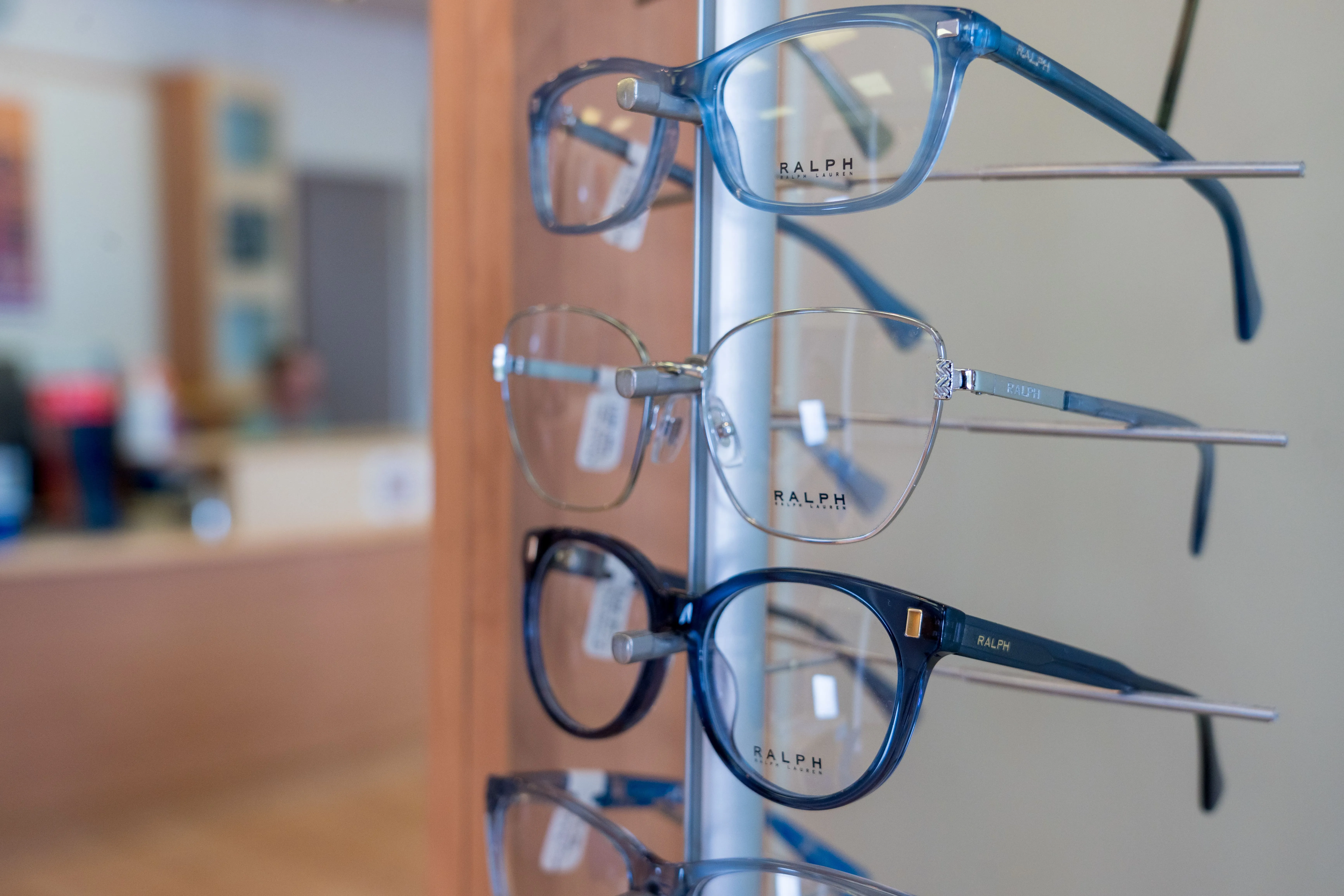 Ralph eyeglasses display with blue and silver frames on stand