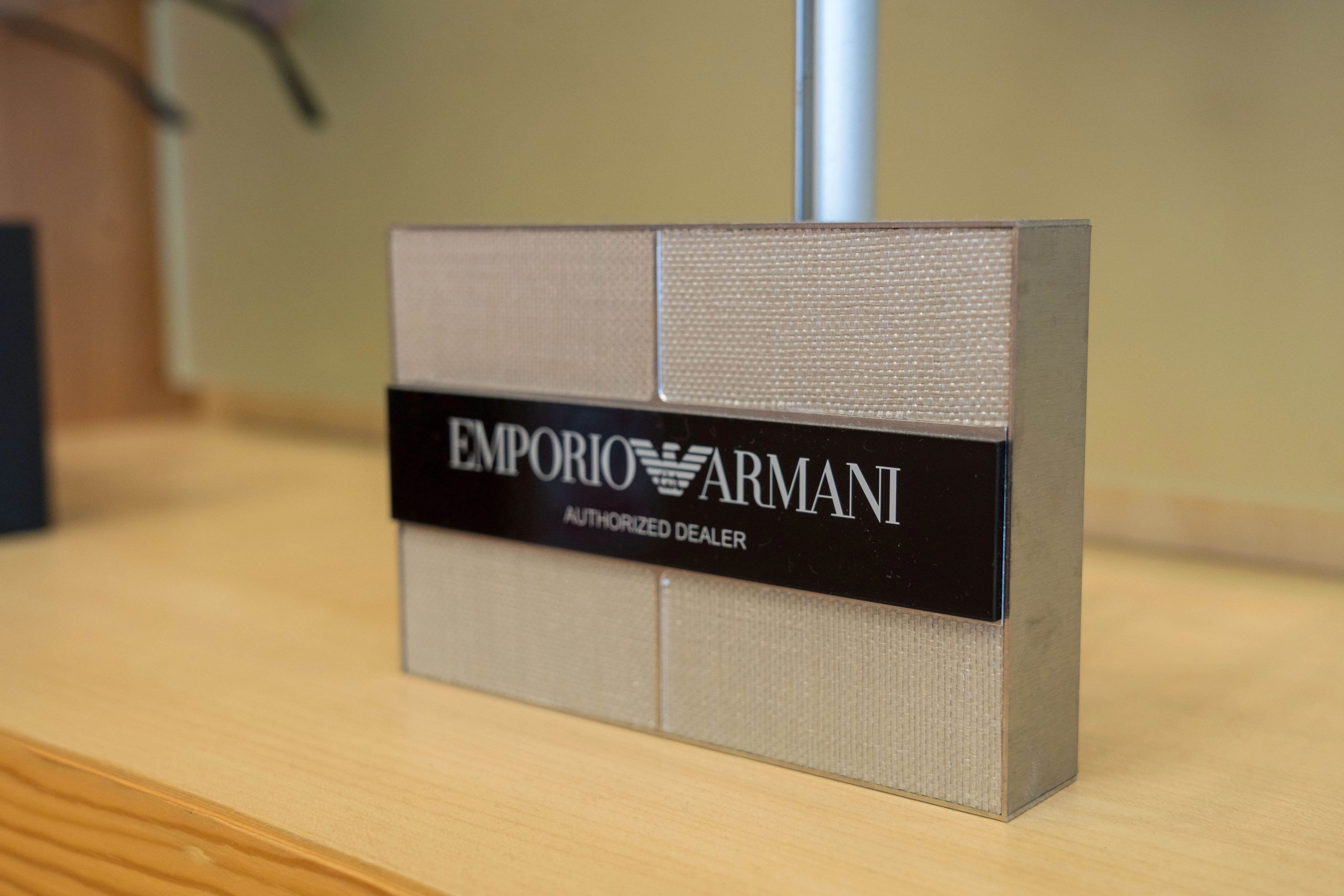 Emporio Armani authorized dealer display sign with textured background