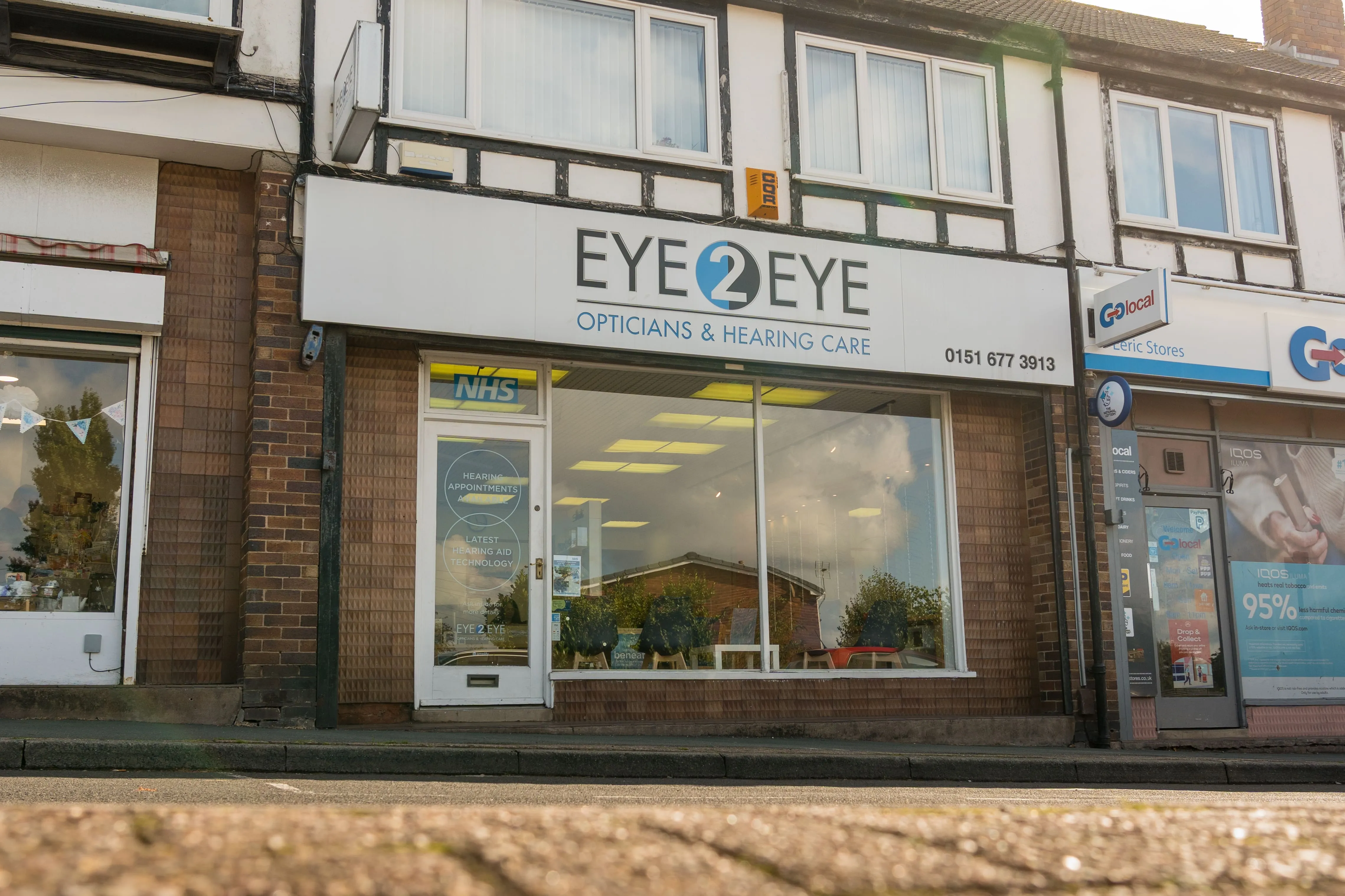 Eye2Eye opticians and hearing care storefront with NHS sign
