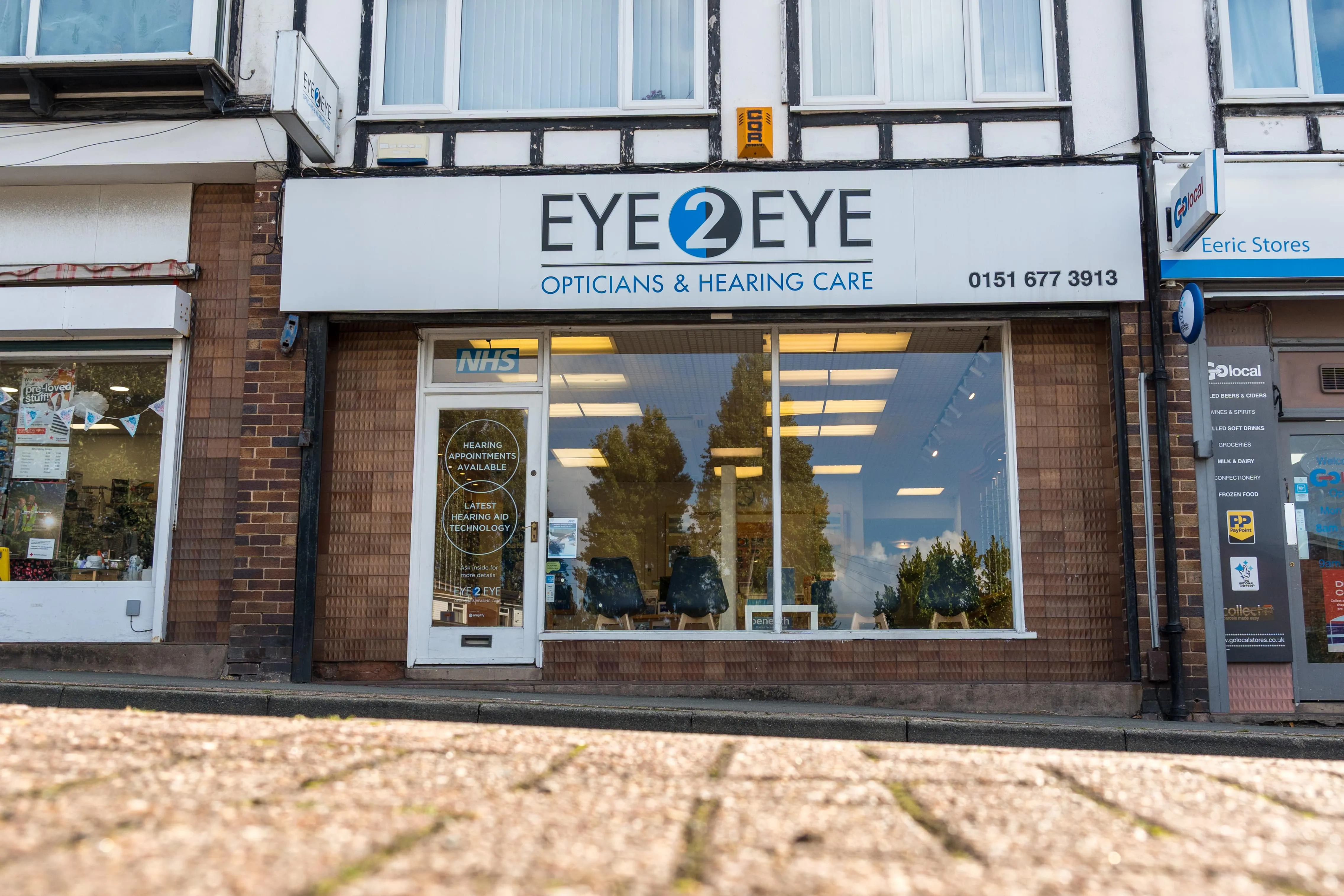 Eye2Eye opticians and hearing care storefront with NHS sign