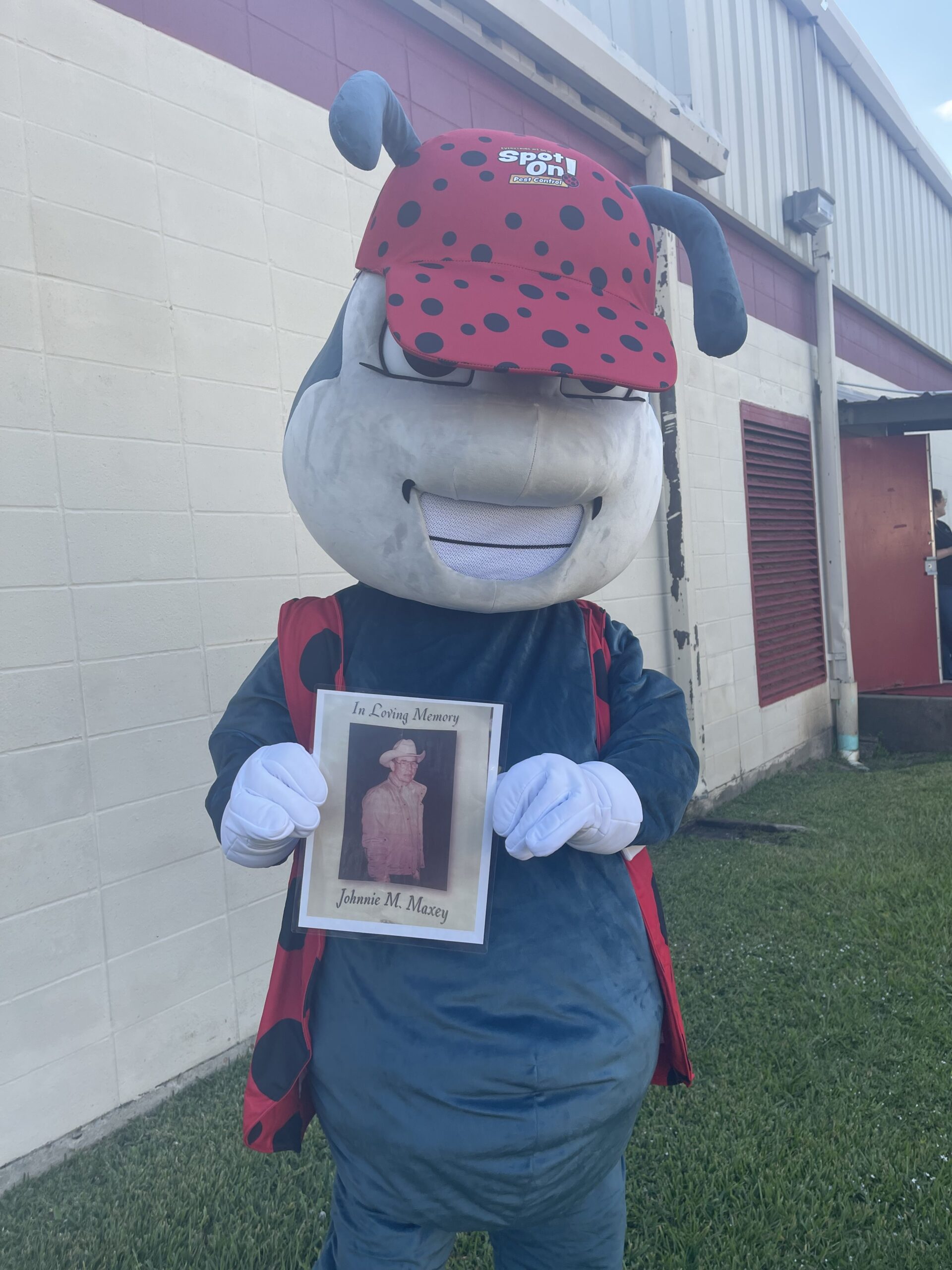 Mascot holds memorial photo of Johnnie Massey.
