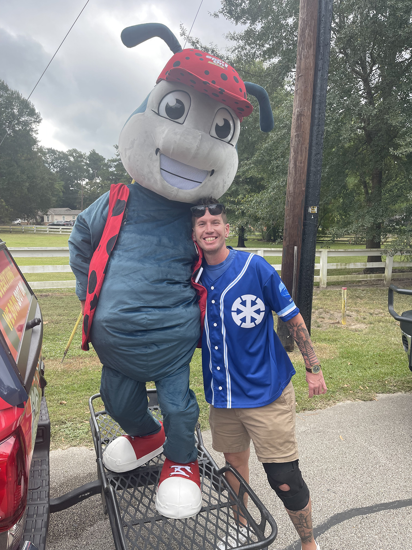 Man posing with a ladybug mascot.