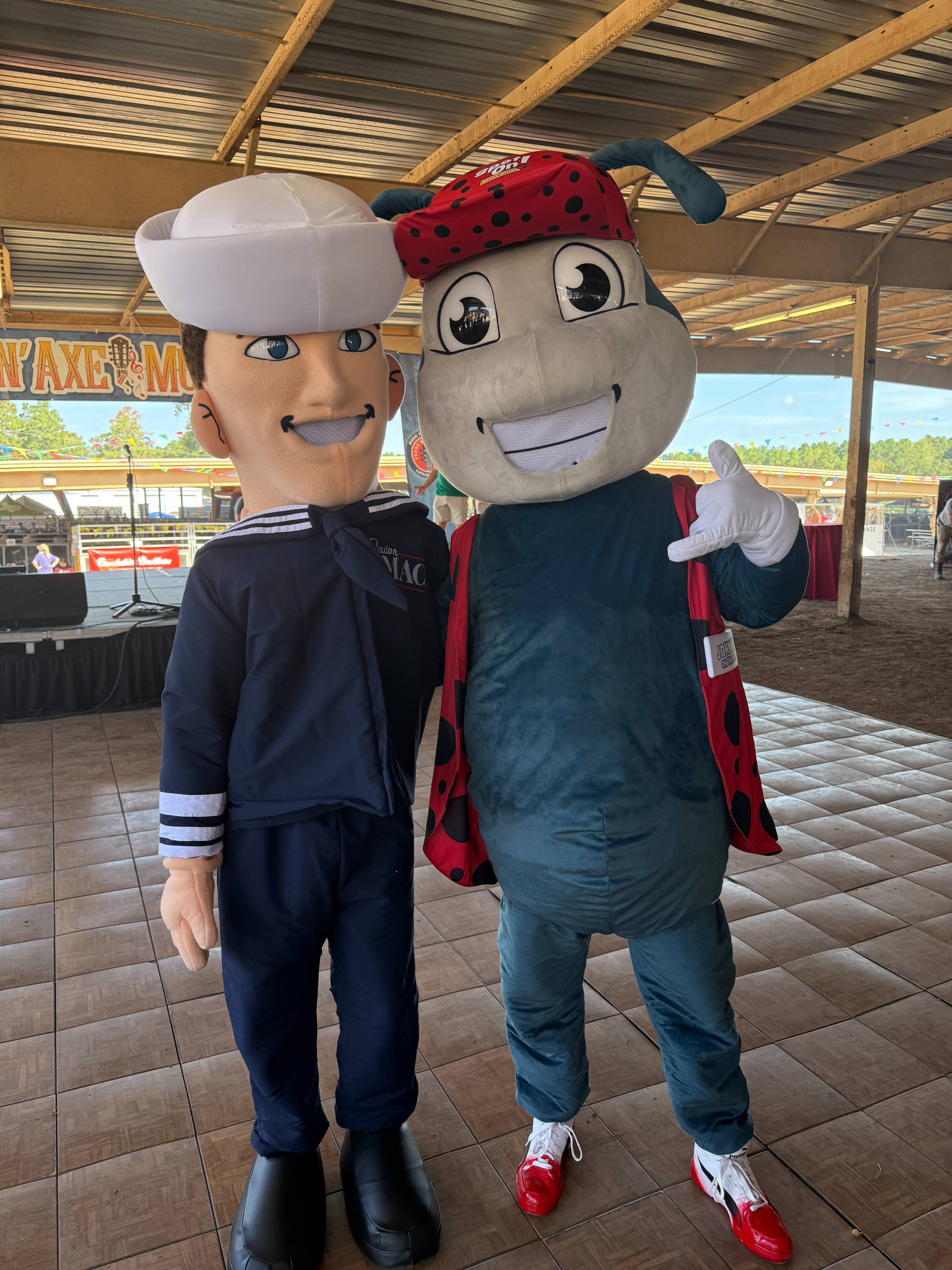 Sailor and ladybug mascots posing together.