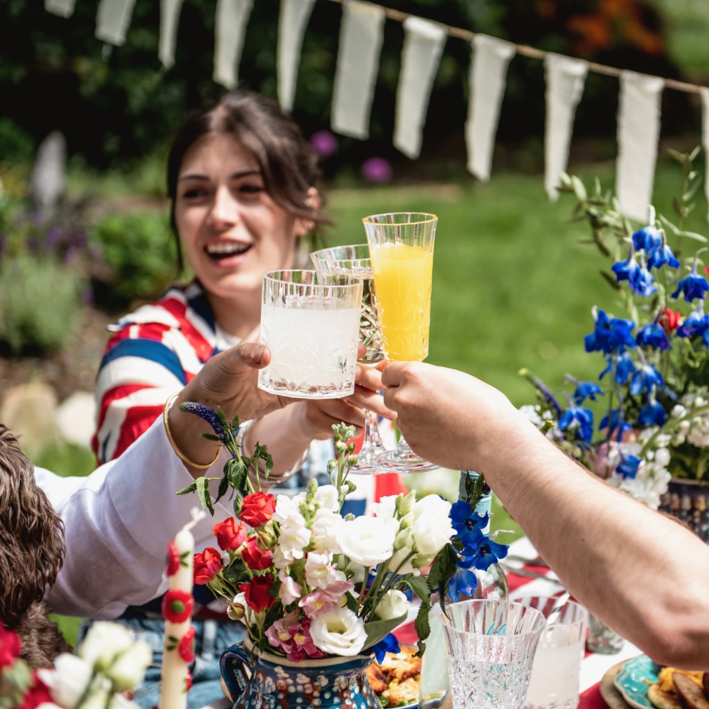 A group of people clinking glasses at a garden party