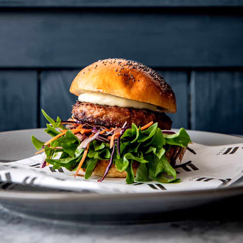 Fego Cafe Veg Burger with curried vegan patty, sweet potato bun, coconut yoghurt, pink onion, rocket, soft herbs & classic fries
