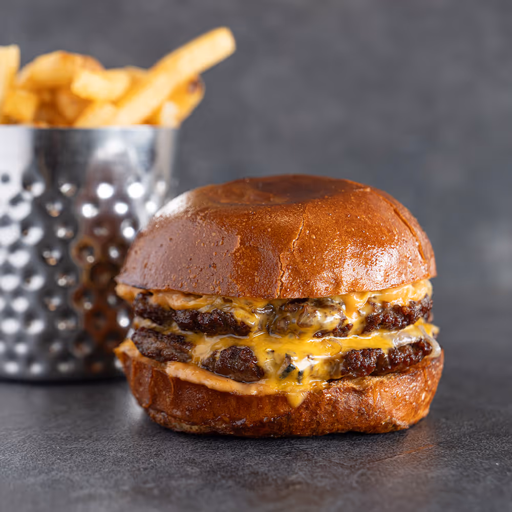 Fego Cafe Smash Burger with house burger sauce, American cheese, onion, 2 beef patties, dill pickle, potato bun & classic fries