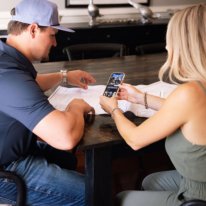Elle Gray Construction contractor reviewing renovation plans with a client, discussing project details and design ideas in Florida.