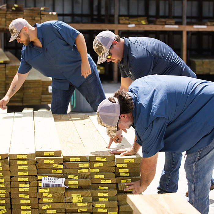 Elle Gray Construction crew inspecting and selecting lumber for a home building project in Florida.