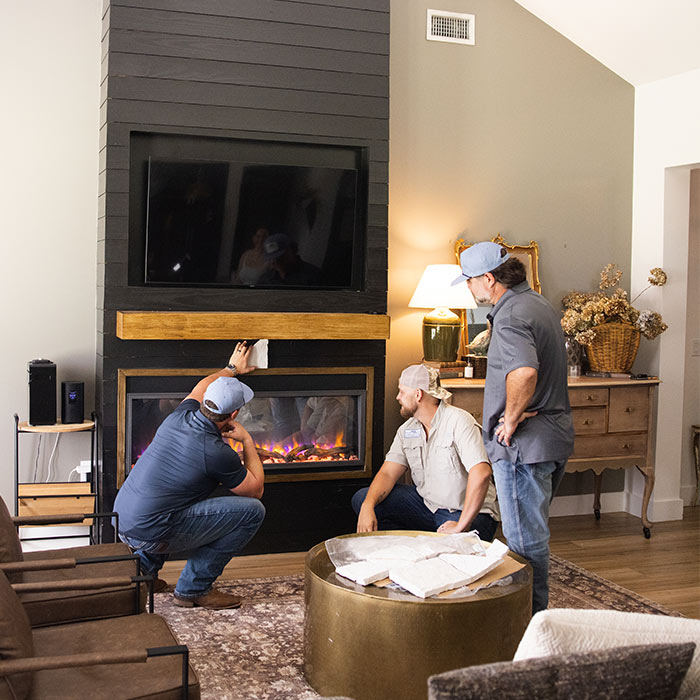 Elle Gray Construction team installing and inspecting a custom fireplace during a home remodel in Florida.