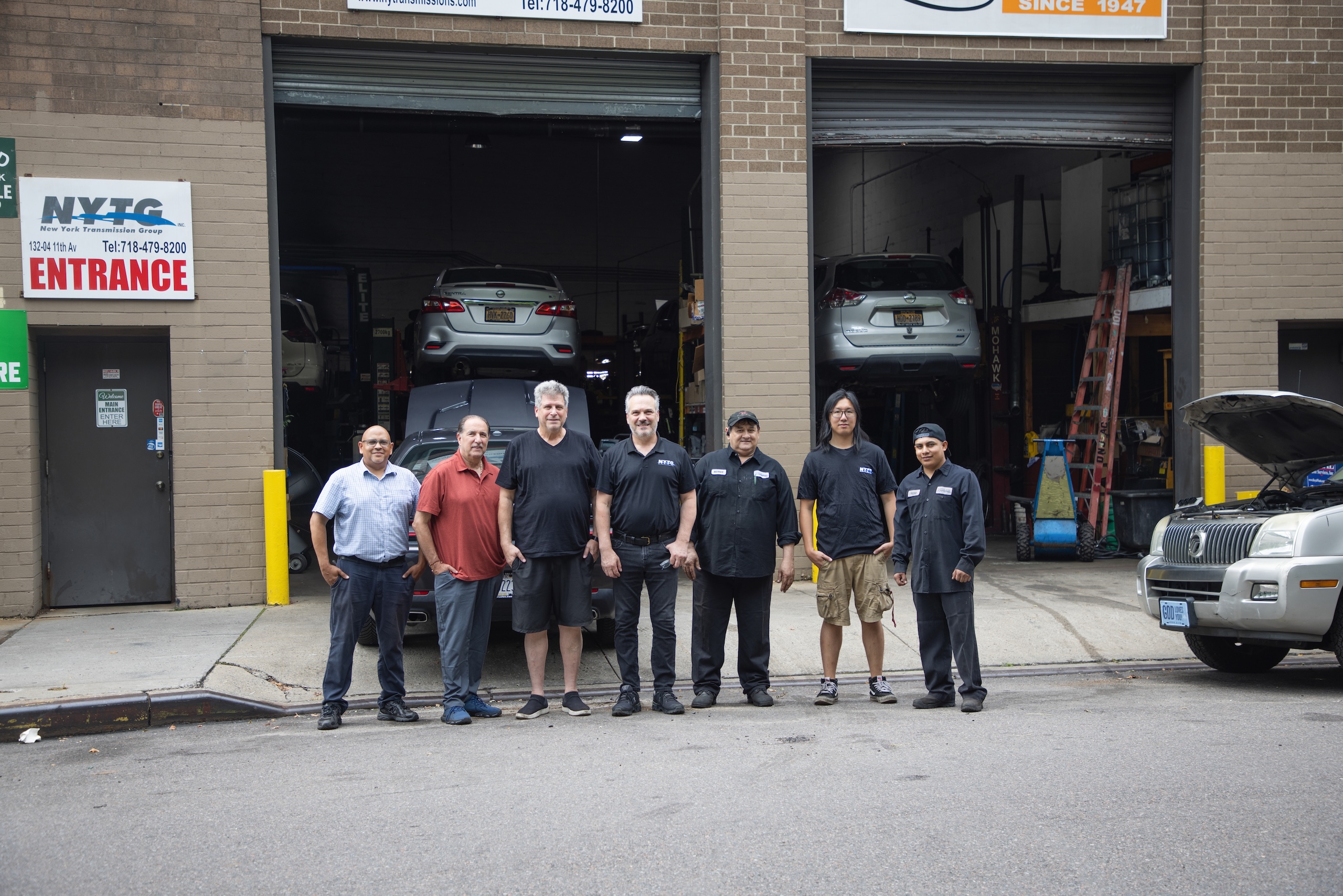New York Transmission Group team of techniccians outside garage doors (wide)