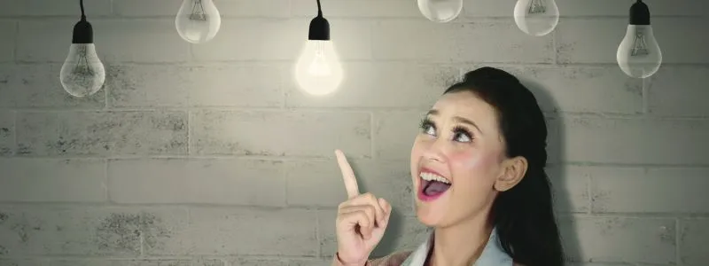 Woman happily pointing to a lit lightbulb. Indicating ways to build your Customer Advocacy Program faster.