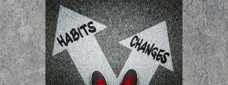 Feet standing at crossroads one arrow says Habits and other says Changes showing importance of change management.