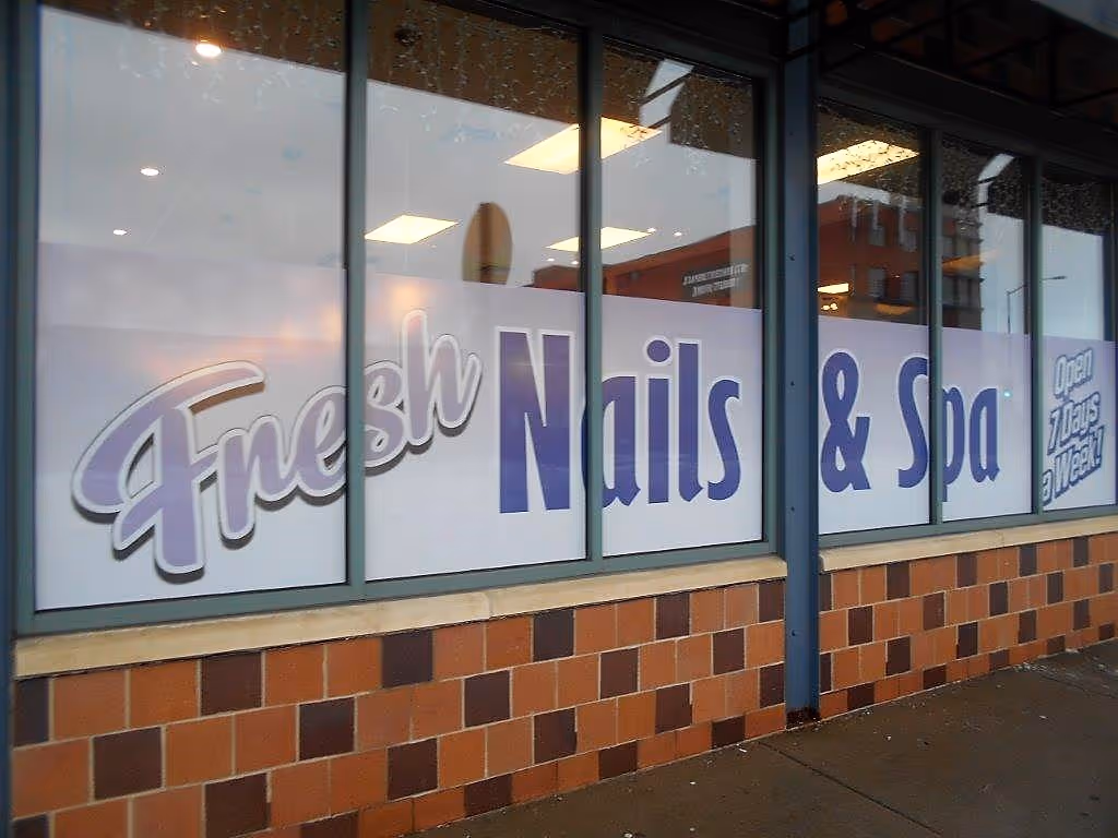 Storefront window with signage reading 'Fresh Nails & Spa Open 7 Days a Week'.