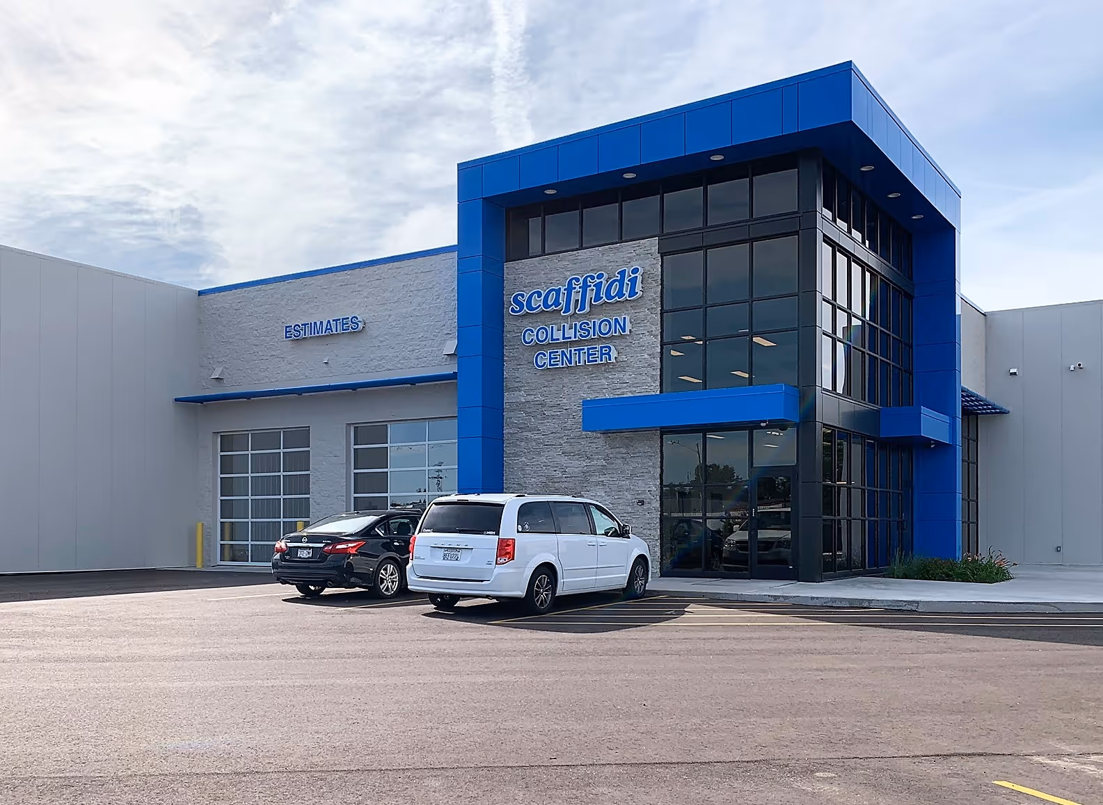 Exterior view of Scaffidi Collision Center building with blue accents and two vehicles parked in front.