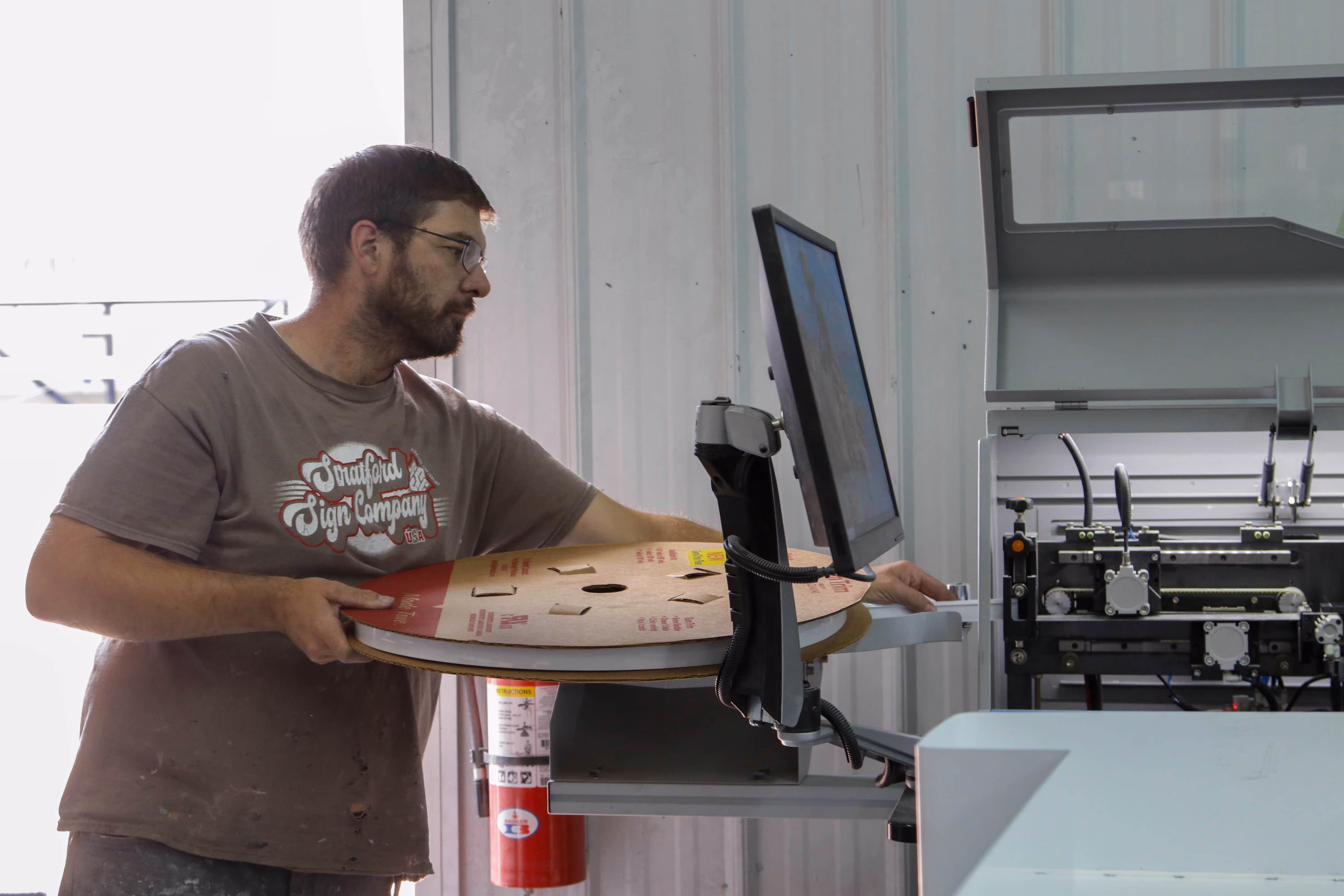 man using a screenprinter st stratford sign company