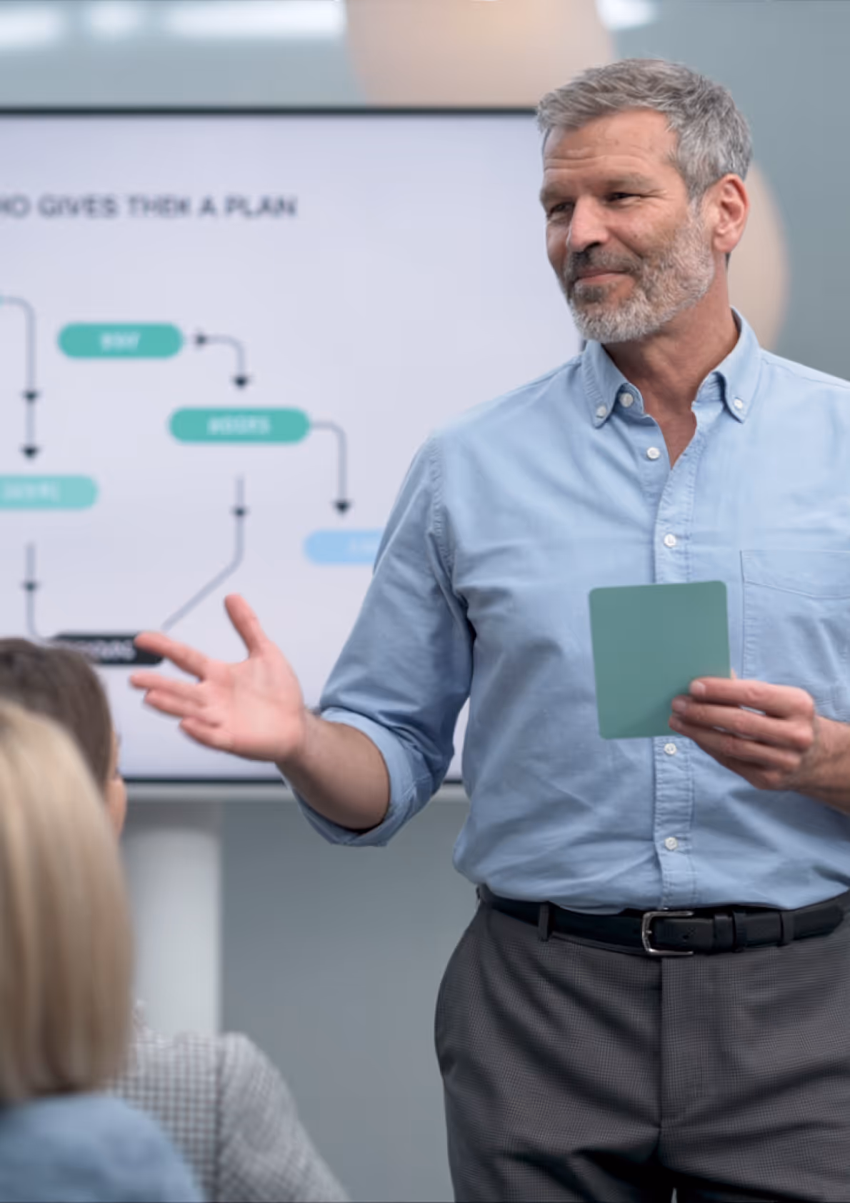 Zakelijke spreker presenteert voor publiek met visueel schema op groot scherm tijdens een StoryBrand workshop.