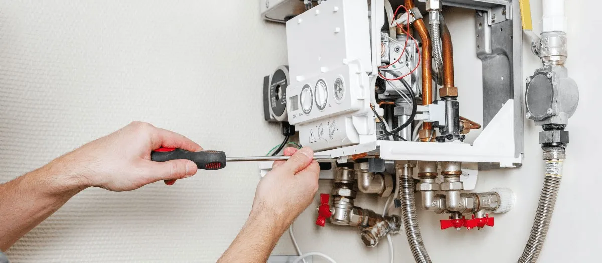 Man repairs tankless water heater.