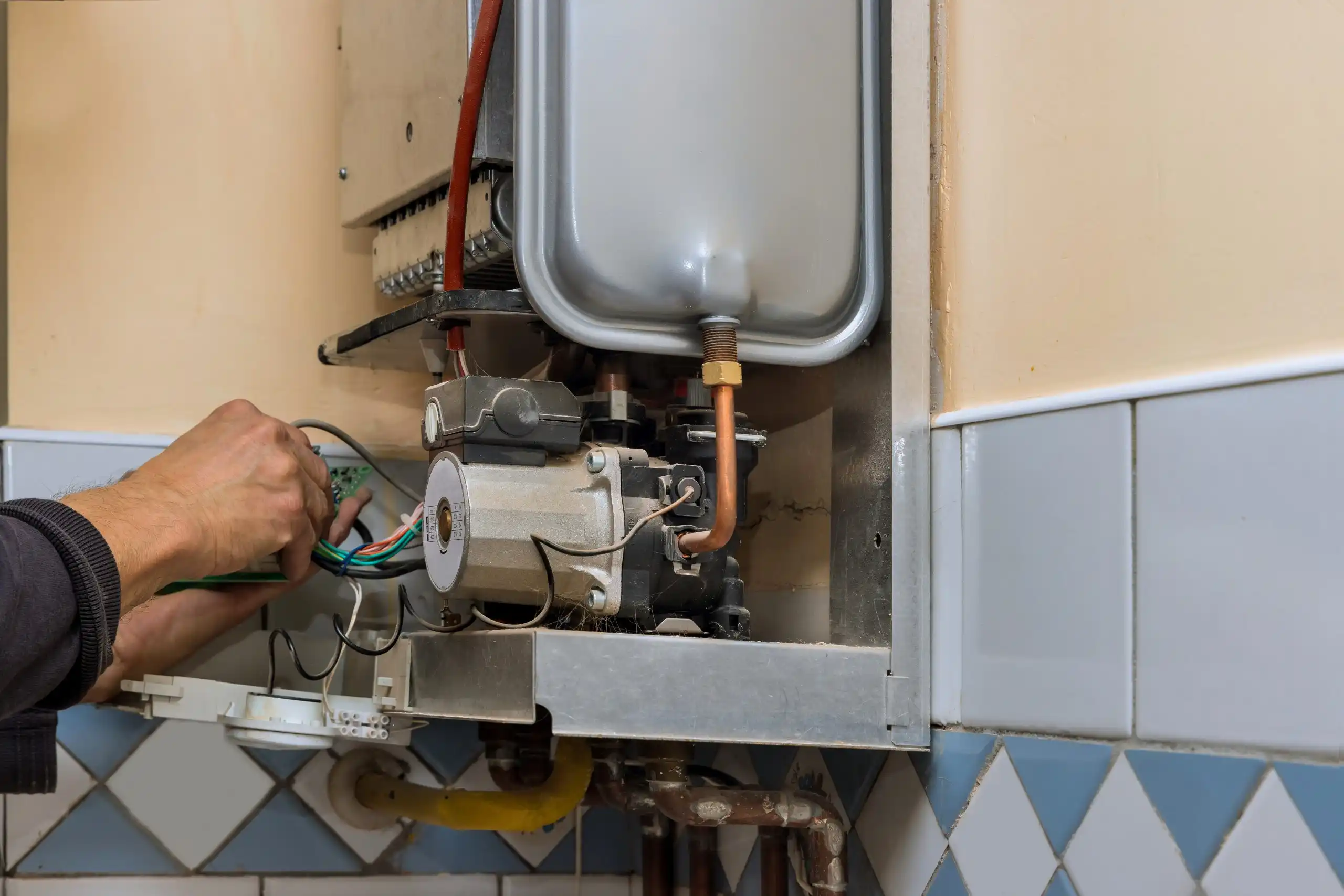 Man performing replacement on boiler.