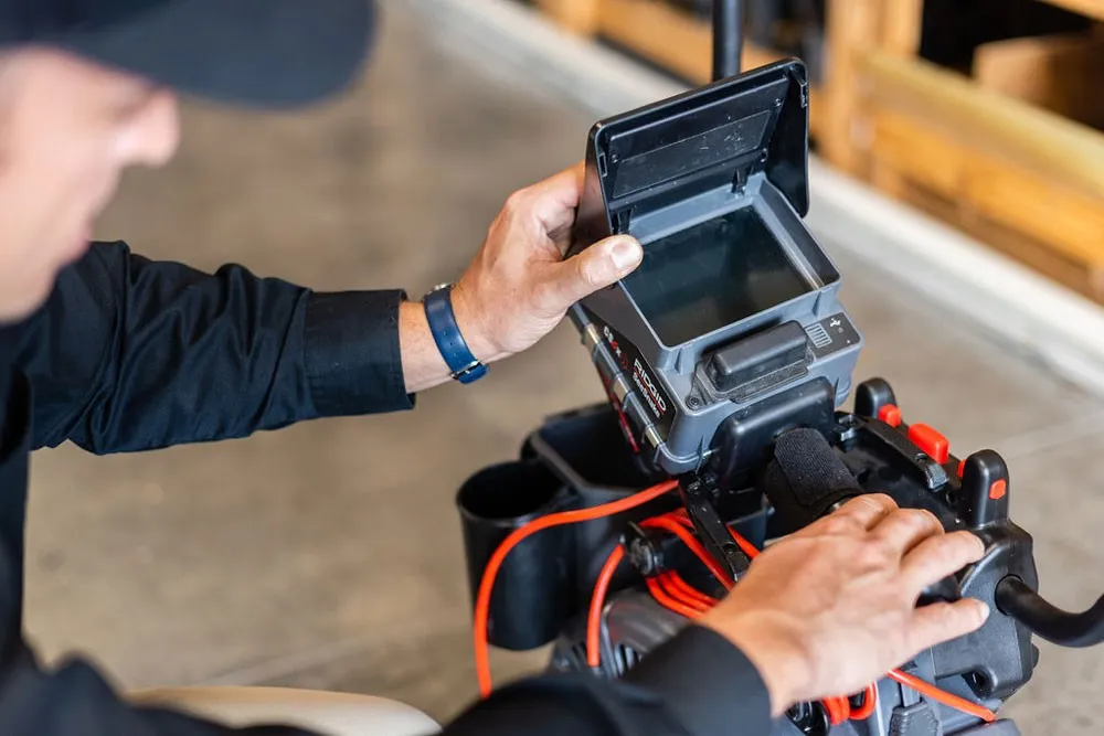 A plumber prepares a sewer camera.