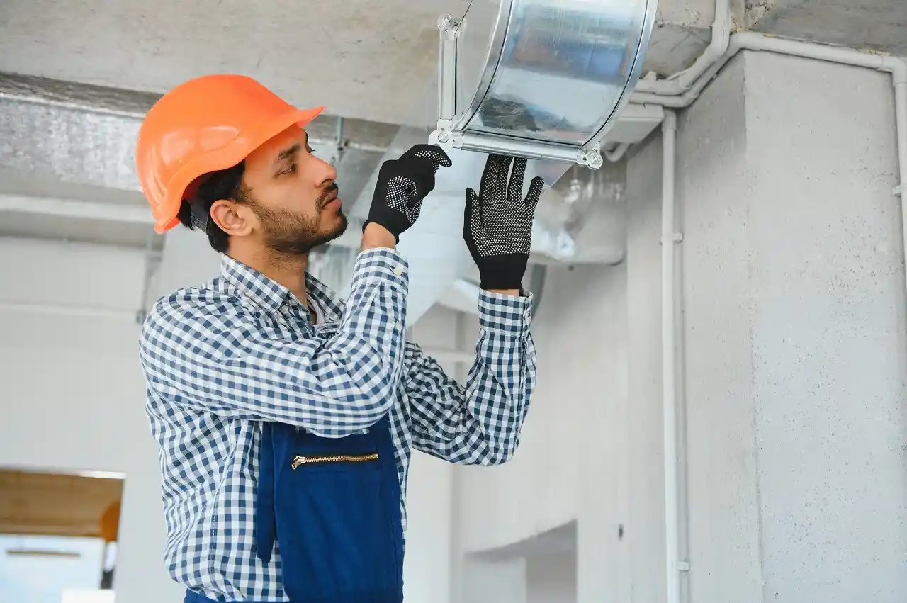 A technician inspects HVAC ductwork.