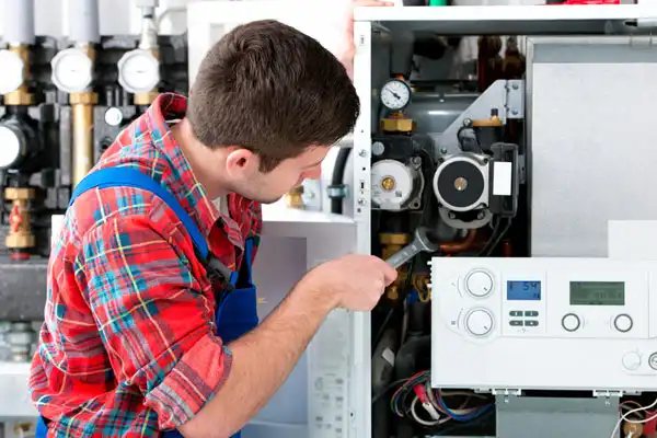 A technician fixes an electric boiler.