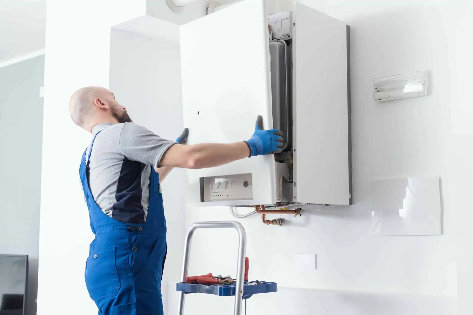 Man replaces boiler on wall.