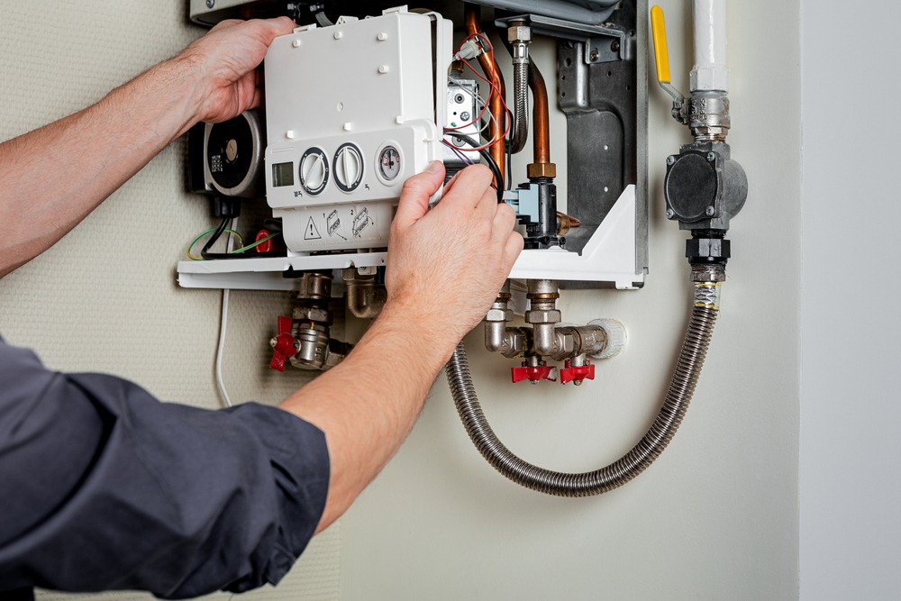 A man works on a boiler.