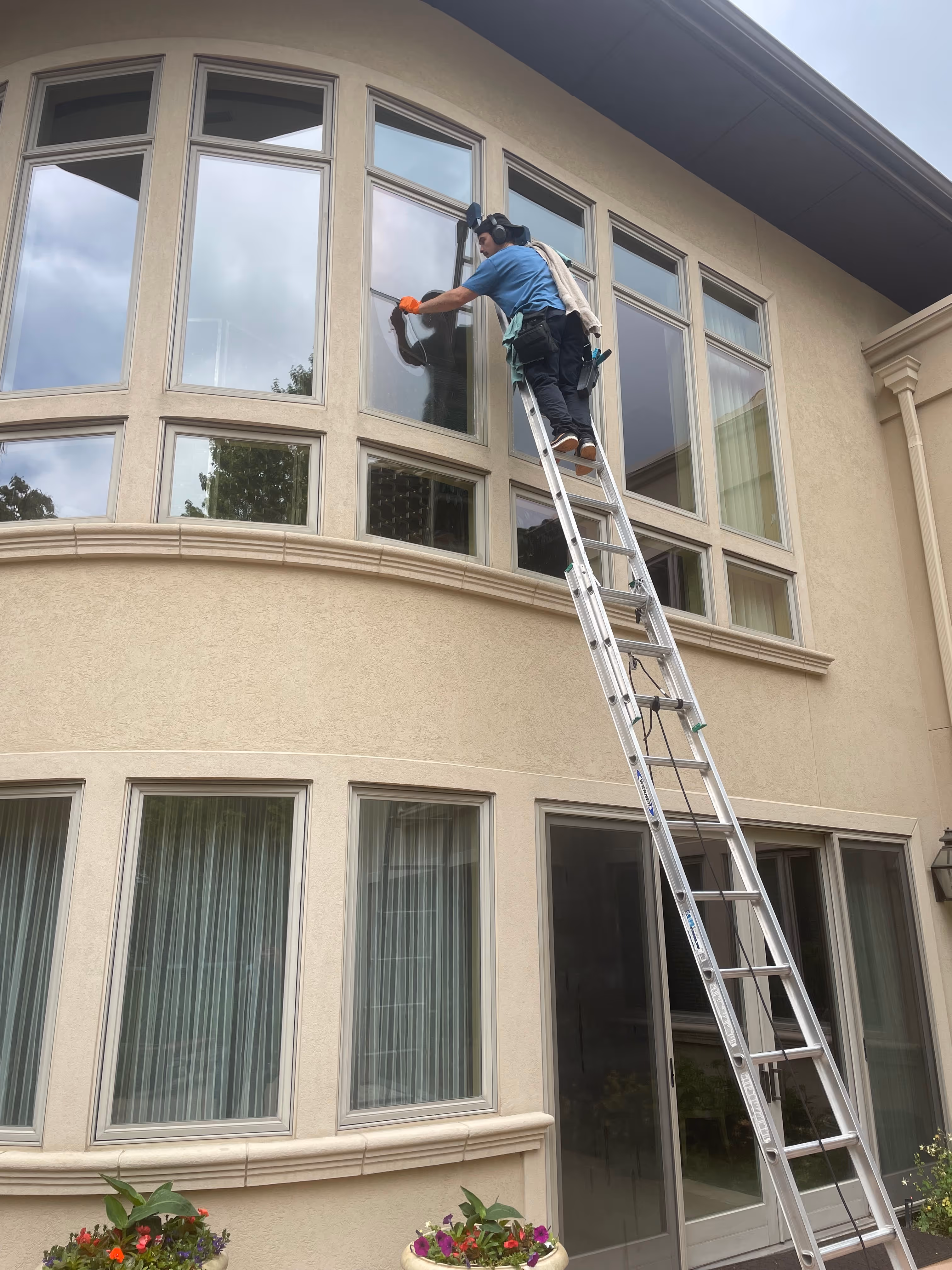 Residential Window Cleaning Technician Squeegeeing Two Story Home