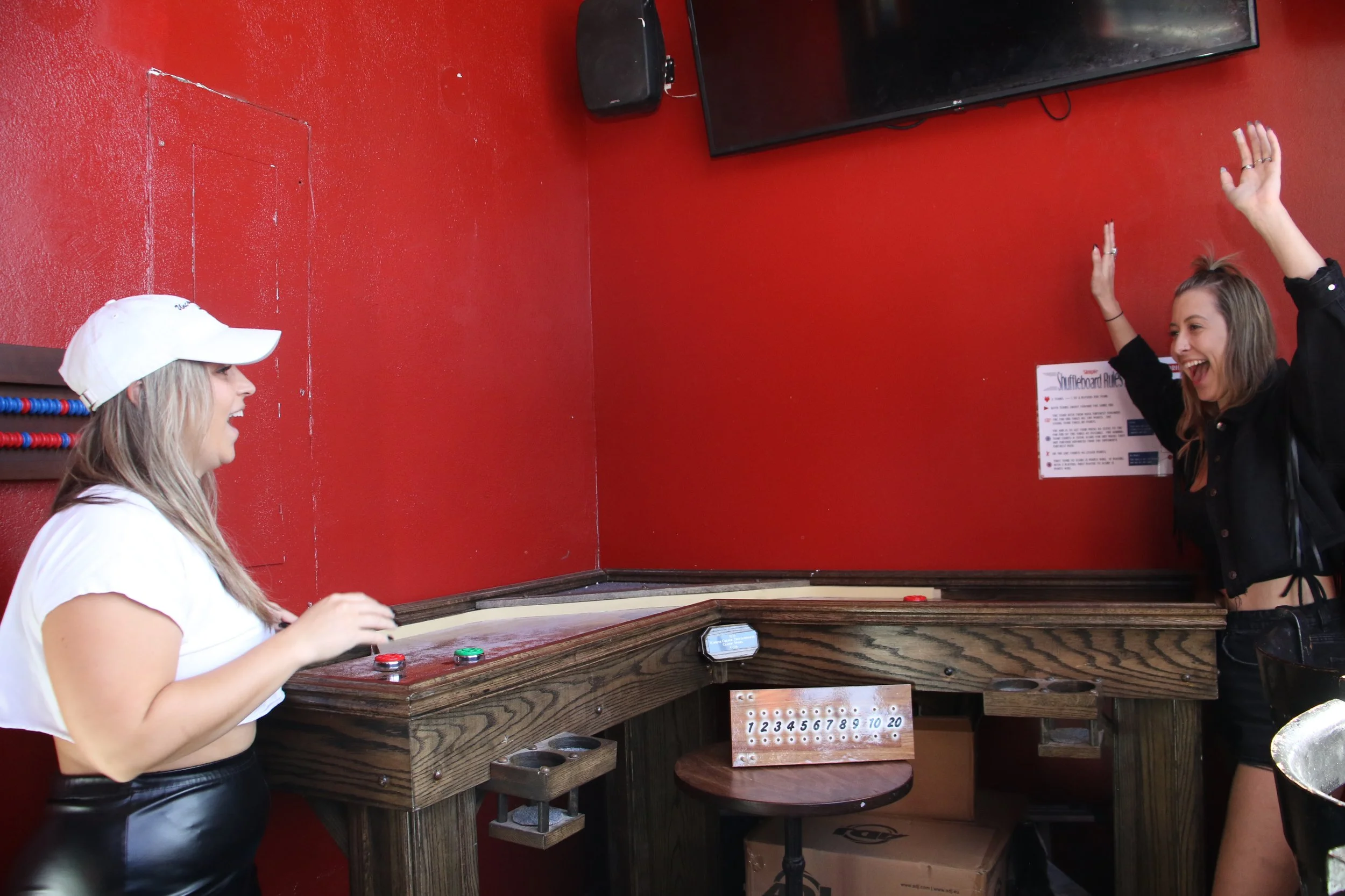 Two girls playing shuffleboard