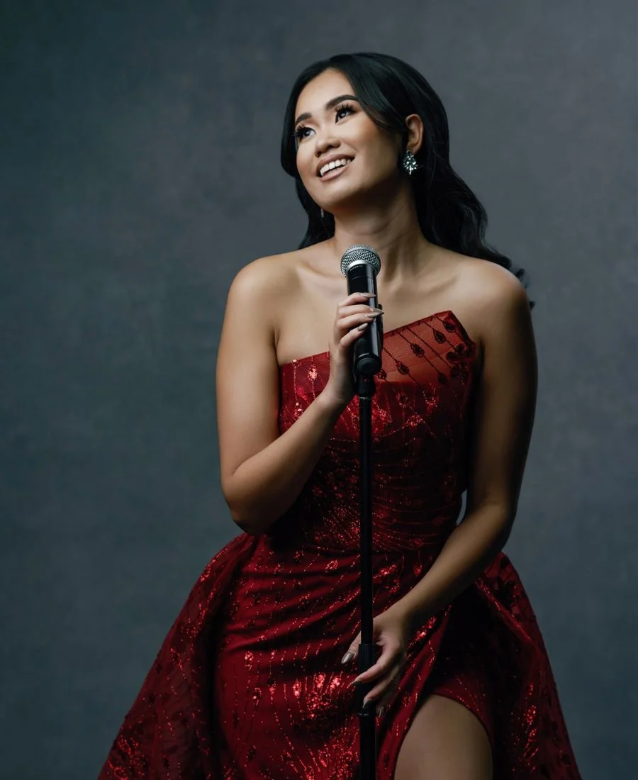 Nicholette Chew in a red dress with microphone.