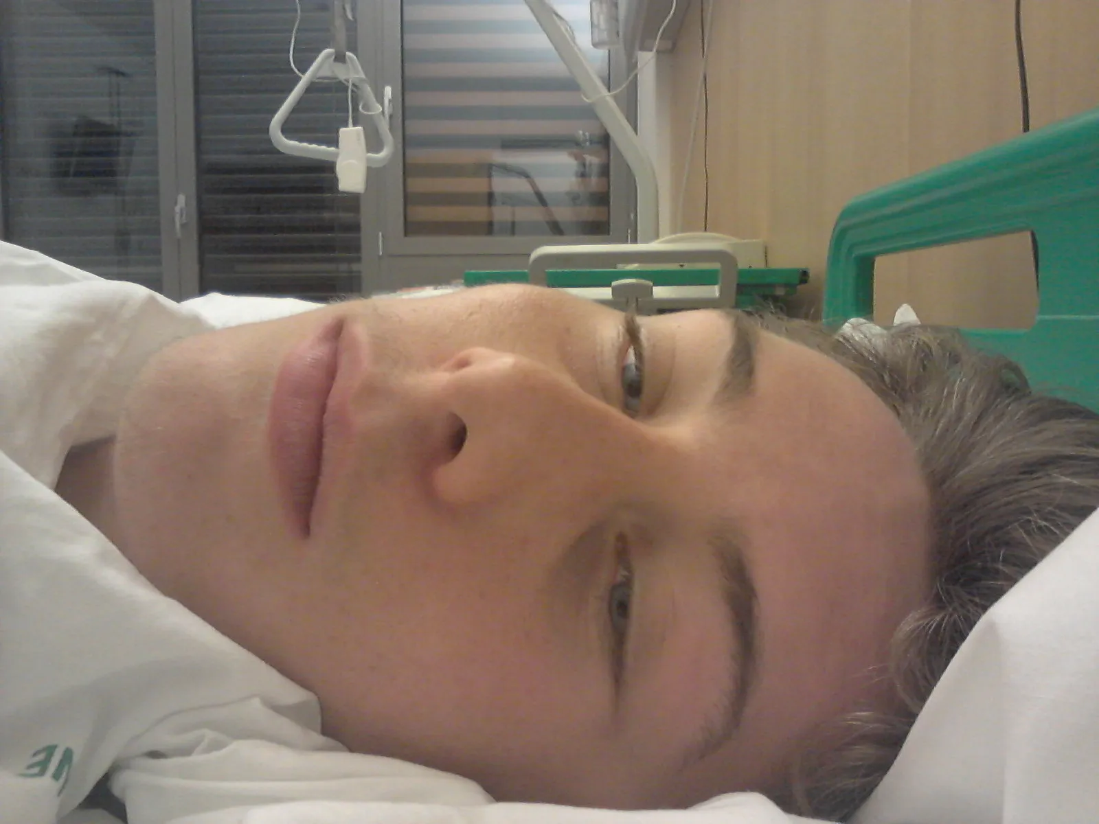 Person liegt im Krankenbett, Nahaufnahme des Gesichts