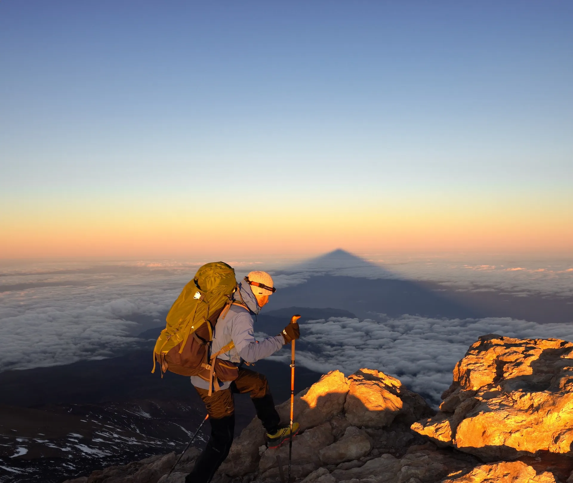Person wandert auf Gipfel über Wolkenmeer