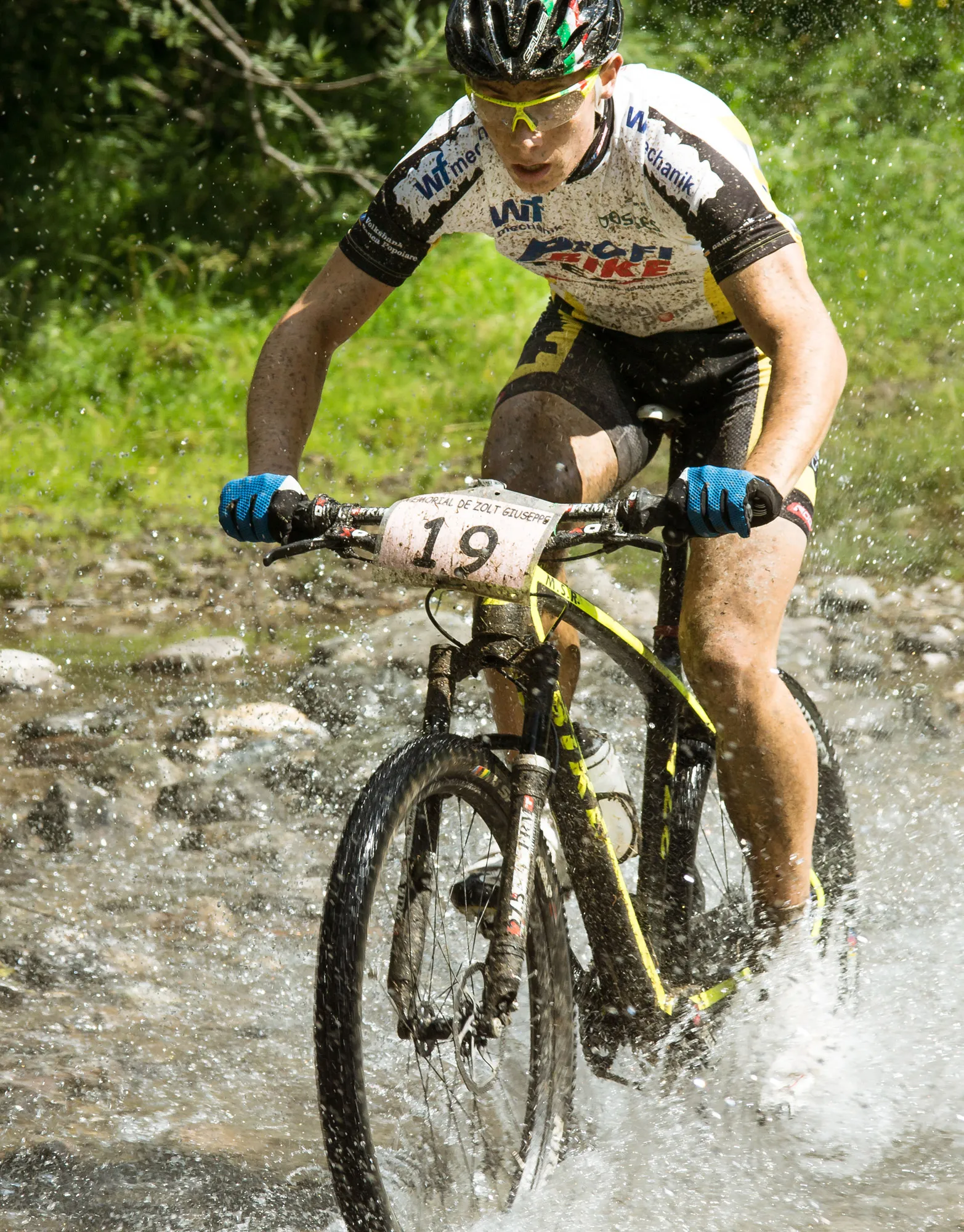 Mountainbiker fährt durch eine Pfütze oder Matschspritzer