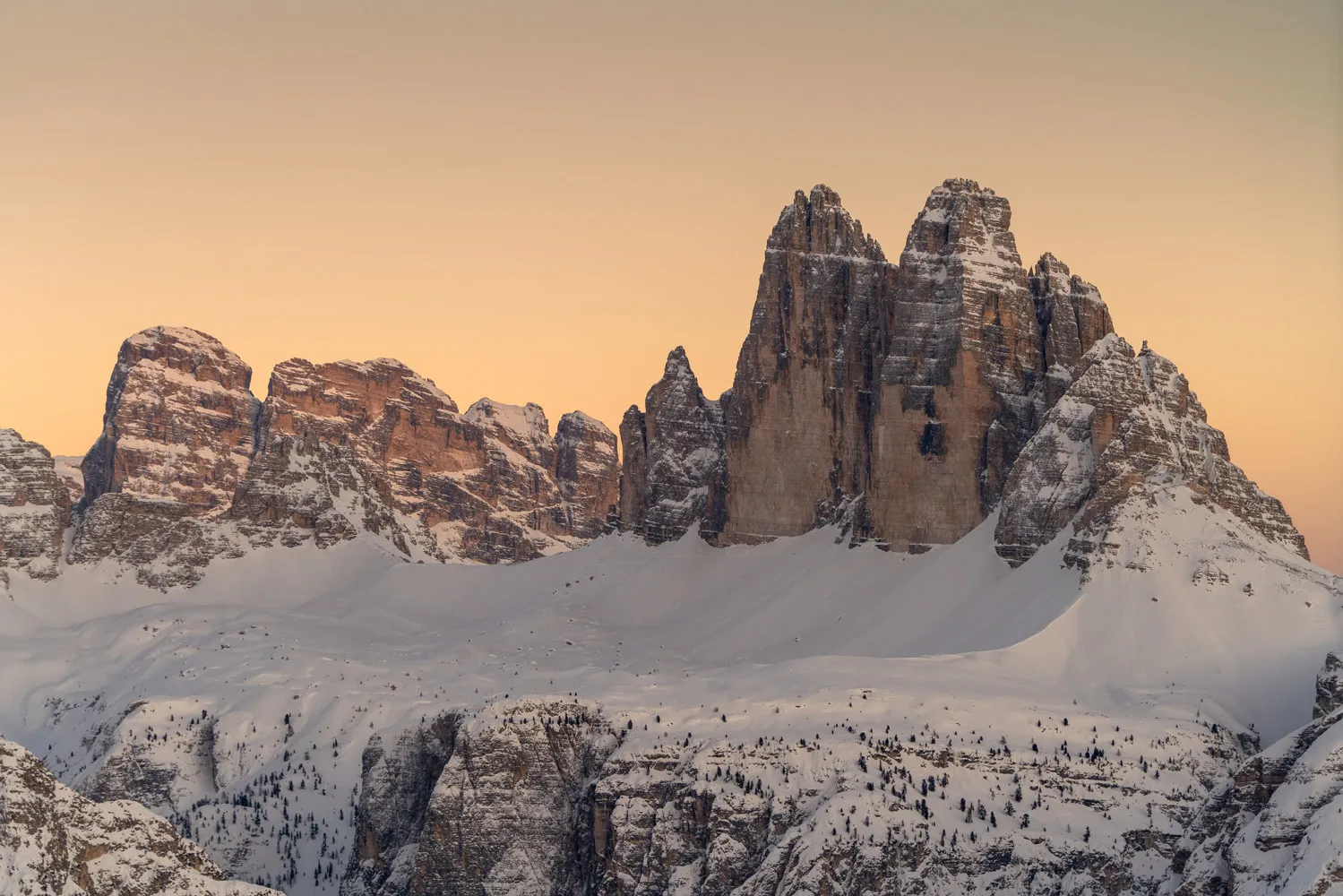 Drei Zinnen bei Sonnenaufgang in Weinterlandschaft