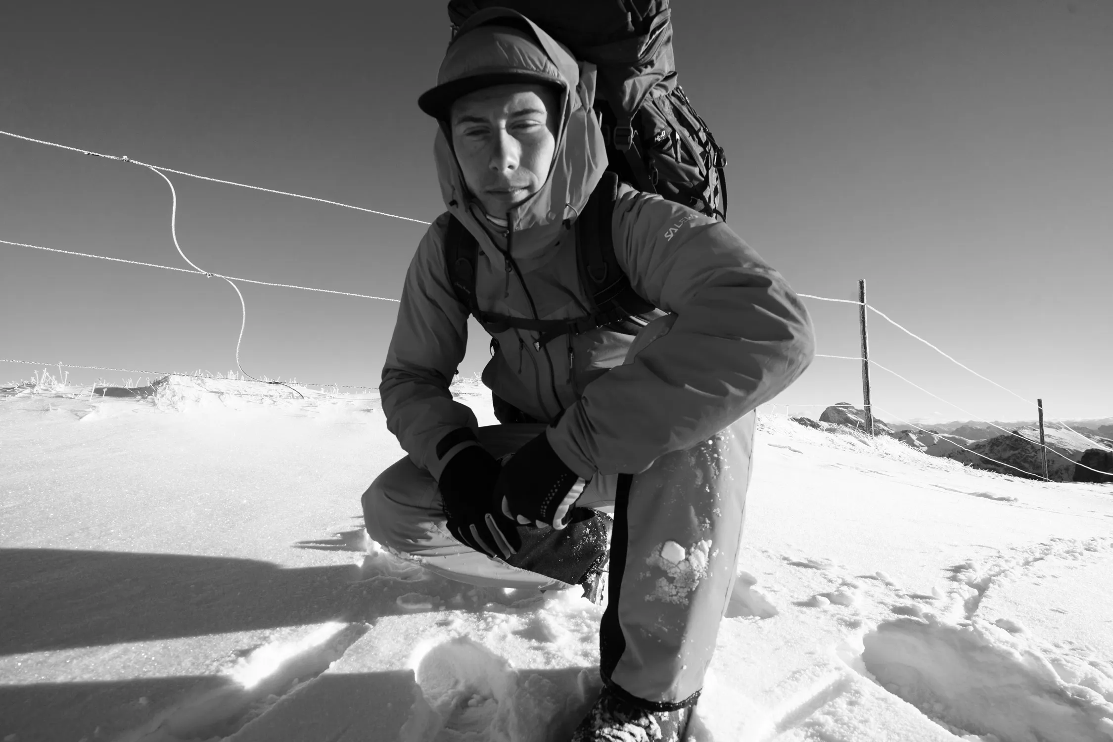 Schwarz-Weiß-Foto einer Person beim Posieren und Wandern im Schnee