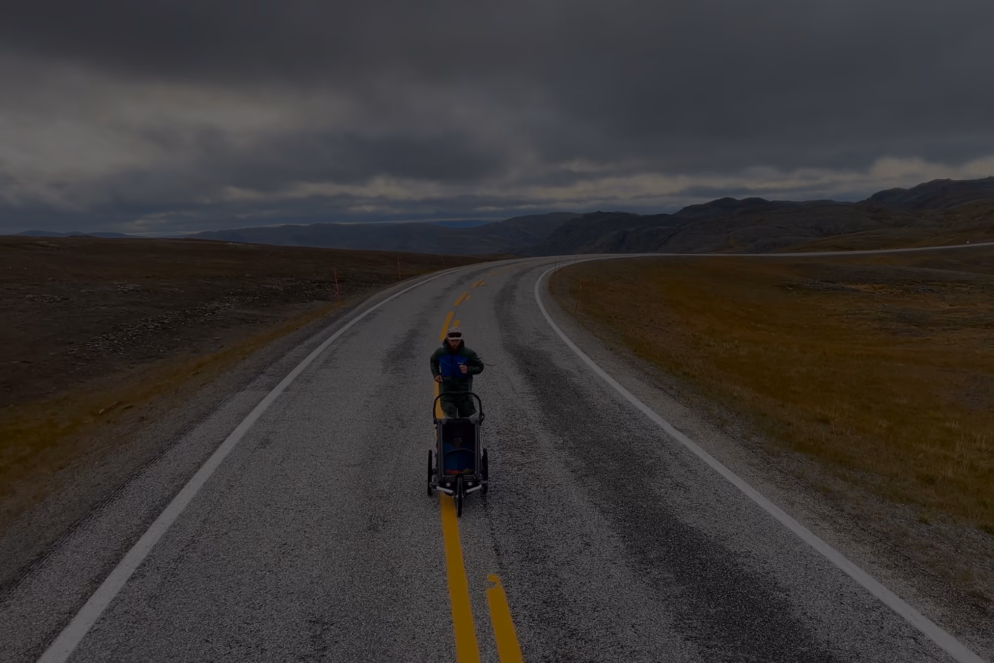 Stefan Santifaller running in Norway with running trailer on street.