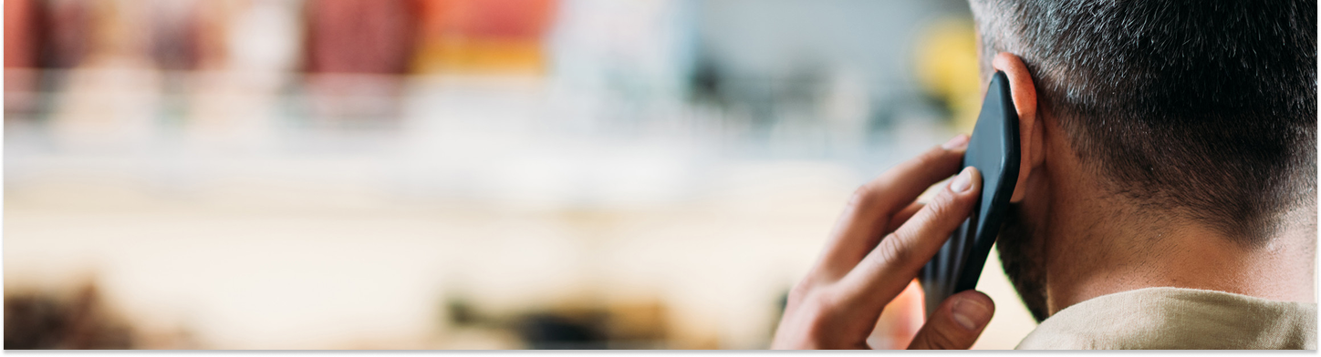 Man with short hair holding a smartphone to his ear during a phone call.