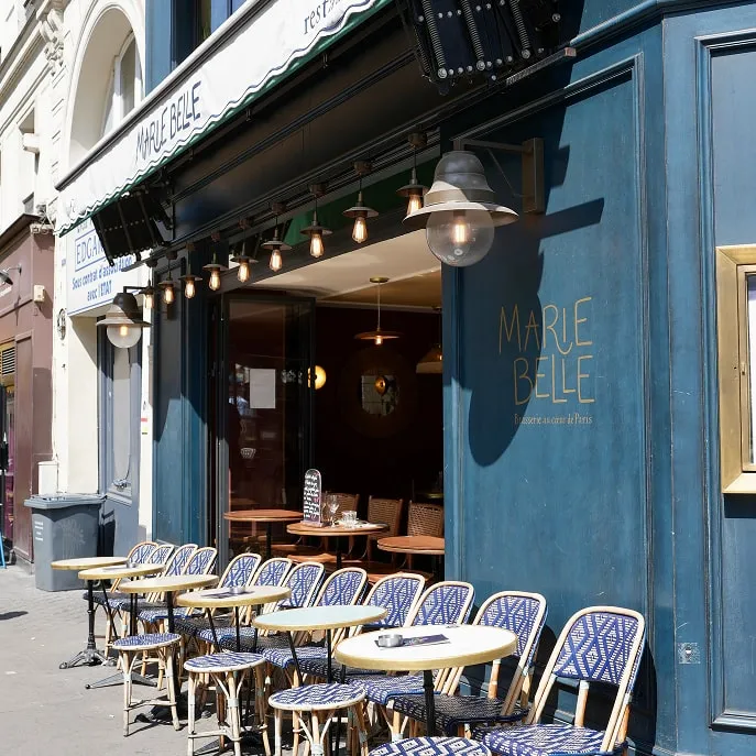 Terrasse extérieure de la brasserie Marie Belle avec chaises bleues